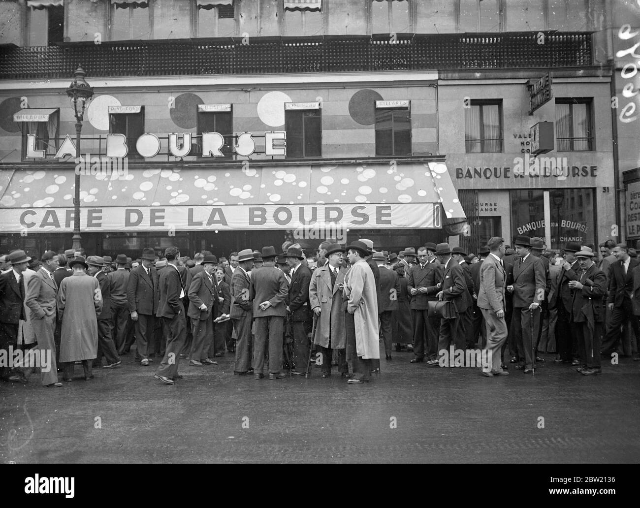 Per evitare speculazioni mentre le misure per affrontare la crisi finanziaria si sono affrancate in Aula, il governo francese ha ordinato la chiusura della Borsa di Parigi fino a nuovo avviso. Il nuovo ministro delle Finanze ha fatto un salto dall’America, sta preparando misure segrete per risolvere la crisi. Gli agenti di borsa discutono della crisi di fronte al caffè di fronte alla Borsa di Parigi. 29 giugno 1937 Foto Stock