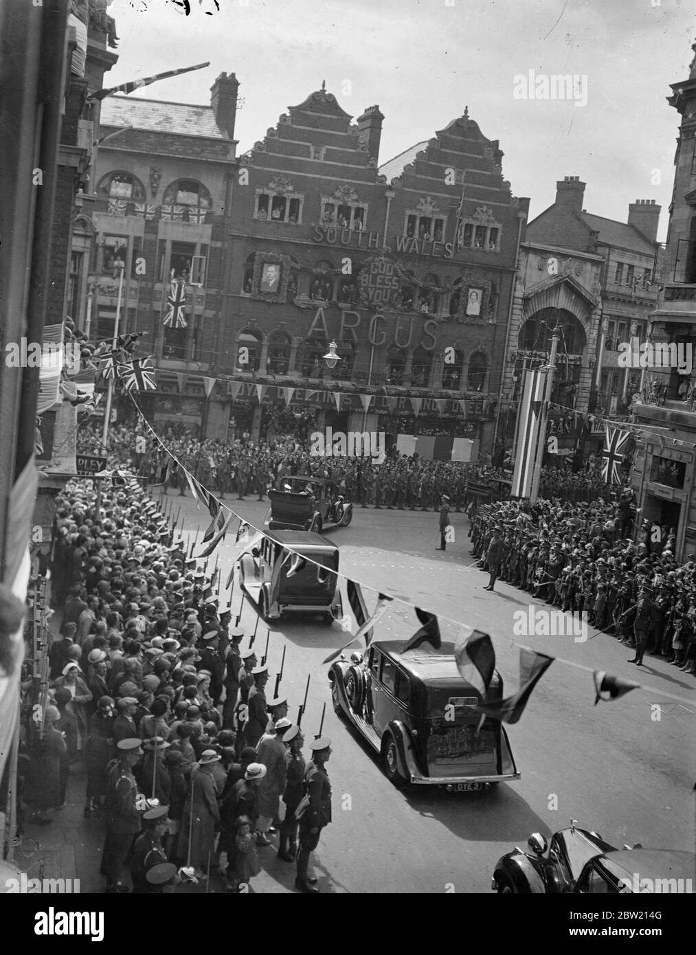 Il genere e la regina in processione formano la via alta al centro civico. Il monarca regnante a visitare la città per più di 300 anni, il re è arrivato con la regina a Newport, Monboccyshire, all'inizio del suo tour del Galles del Sud. 14 luglio 1937. Foto Stock