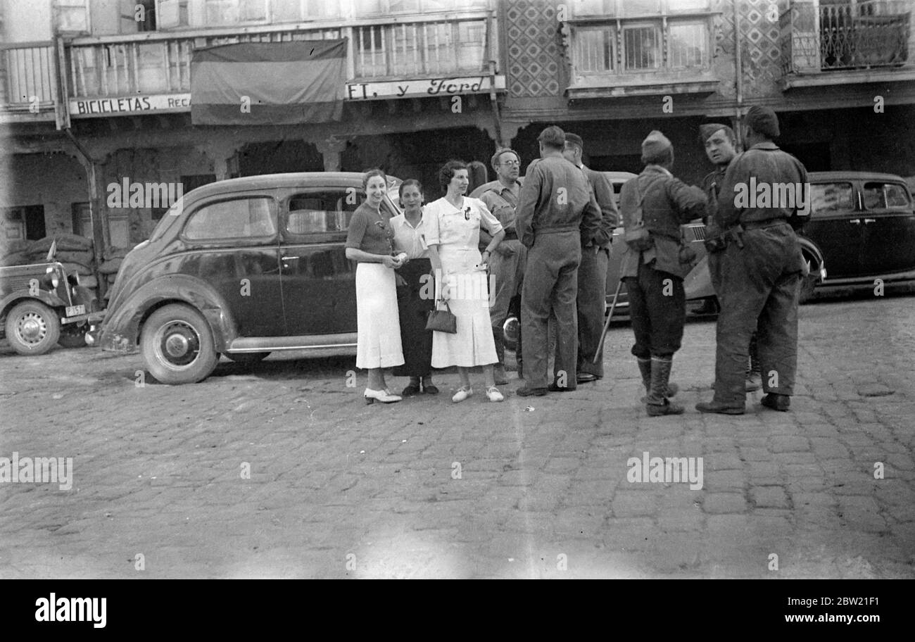 Donne di Reinosa che parlano con i soldati ribelli dopo la cattura della città. Le forze ribelli spagnole avanzano rapidamente a Santander, nella Spagna settentrionale, catturarono una delle più importanti città manifatturiere del paese e del centro dell’abbigliamento. L'occupazione è stata della massima importanza strategica perché ha unito due fianchi della reclusione colpita di membri di villaggi dove ci sono truppe governative. 19 agosto 1937 Foto Stock