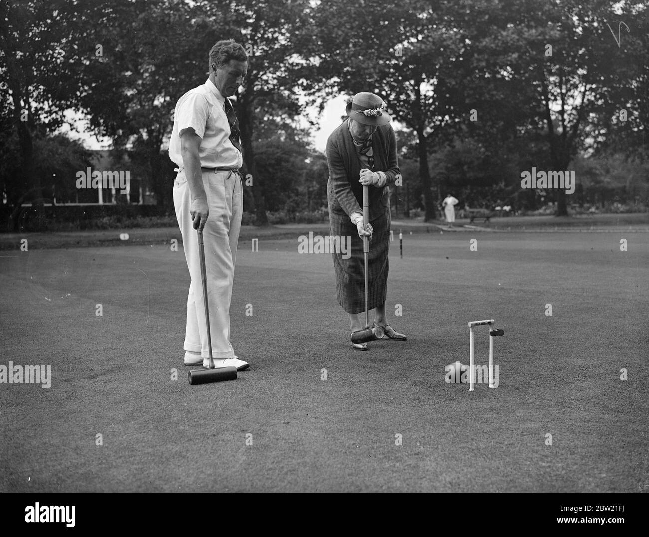 La signora Beatrice Harris dell'Australia gioca contro il dottor RW Grey nelle semifinali della gara di croquet Roehampton Challenge Cup al Roehampton club di Londra. 18 agosto 1937. Foto Stock