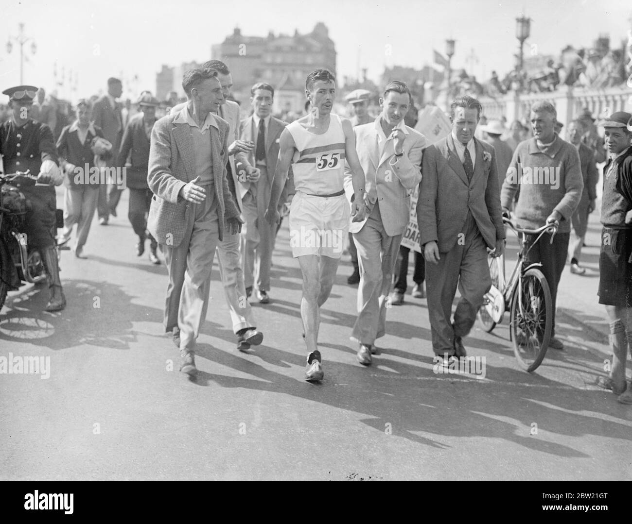 Harold Whitlock, campione olimpico e vincitore degli ultimi tre anni, finendo la gara di Brighton. Dopo aver gareggiato nella passeggiata annuale da Londra a Brighton organizzata dal club di camminata Surrey. Ha coperto il percorso di 52 miglia in otto ore due minuti 36 secondi. Con George Cummings, campione dei Guiani britannici, che è venuto 4000 miglia per competere e E.A. Giuria del club sportivo Southdown Motors. 4 settembre 1937. Foto Stock