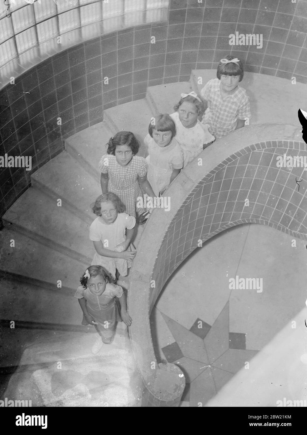 Le scale a chiocciola sono una caratteristica della nuova Gladstone Park Infant's School, che è in fase di costruzione a Sherrick Green Road. Gli architetti considerano questa forma di scale il tipo più sicuro in caso di emergenza, non c'è alcuna possibilità che i bambini siano bloccati agli angoli come con le scale ordinarie. Bambini su una delle nuove scale a spirale. 1 settembre 1937 Foto Stock