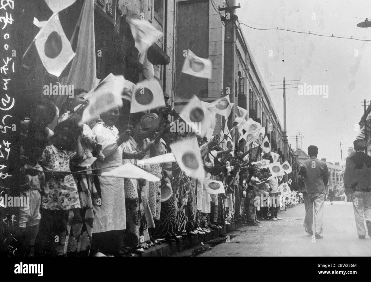 Folle di donne e bambini, nei loro pittoreschi kimono, sventolando la bandiera giapponese che porta il simbolico Sole nascente mentre costeggiavano le strade per rallegrare le truppe che lasciano Tokyo per rafforzare le forze giapponesi in Cina. Il Giappone sta ora facendo una grande spinta su Shanghai. 12 settembre 1937 Foto Stock