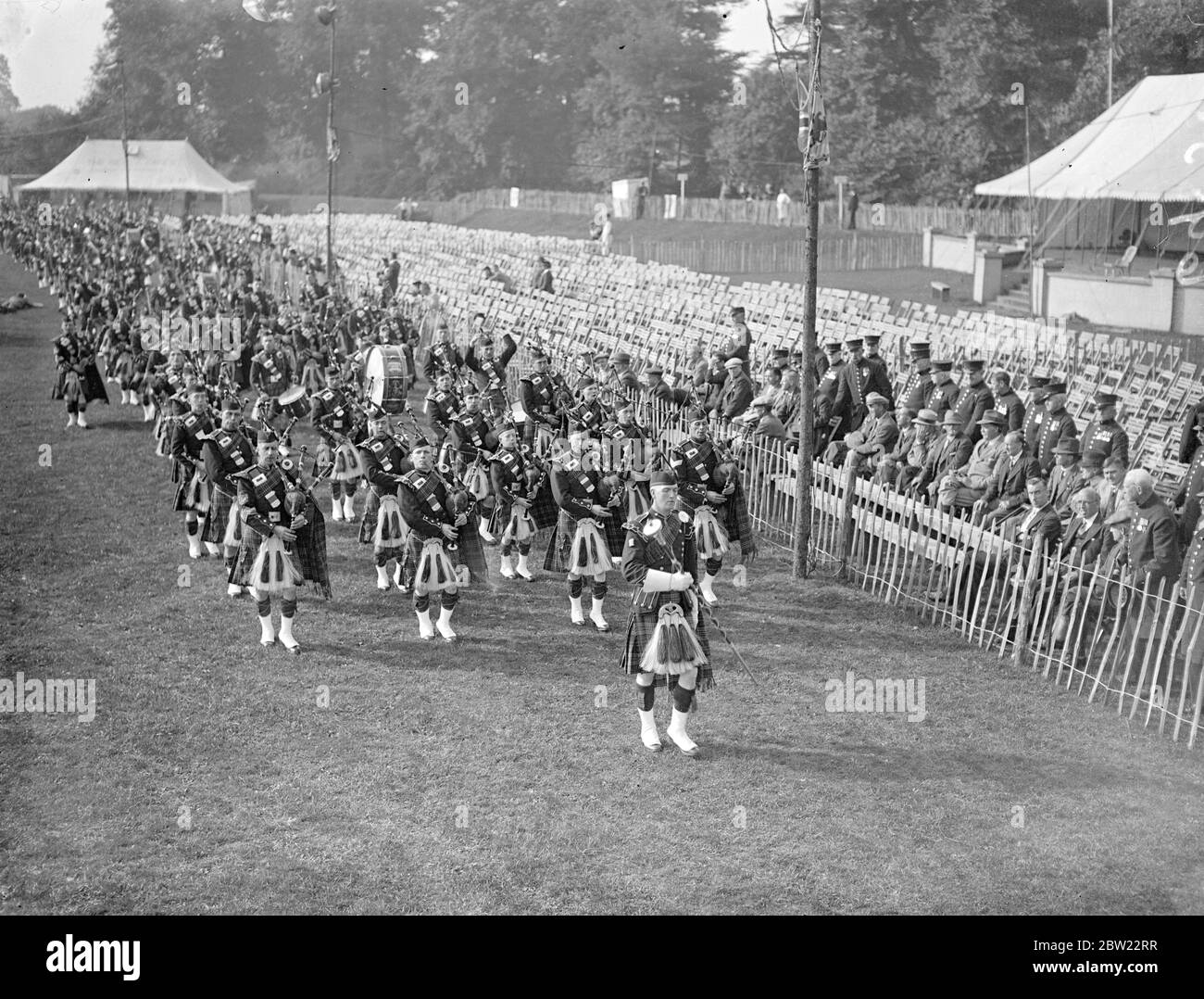 Le bande di Pipe si sfilarono al raduno degli altipiani, quando i clan kilted invasero il ranelegh club, avanzarono a competere nel primo raduno degli Highland tenuto a Londra per molti anni. Le immagini, MR A.B Weir, per tre anni campione di tutto il ciclo ai Giochi del cowal che lanciano il caber. 29 settembre 1937. Foto Stock