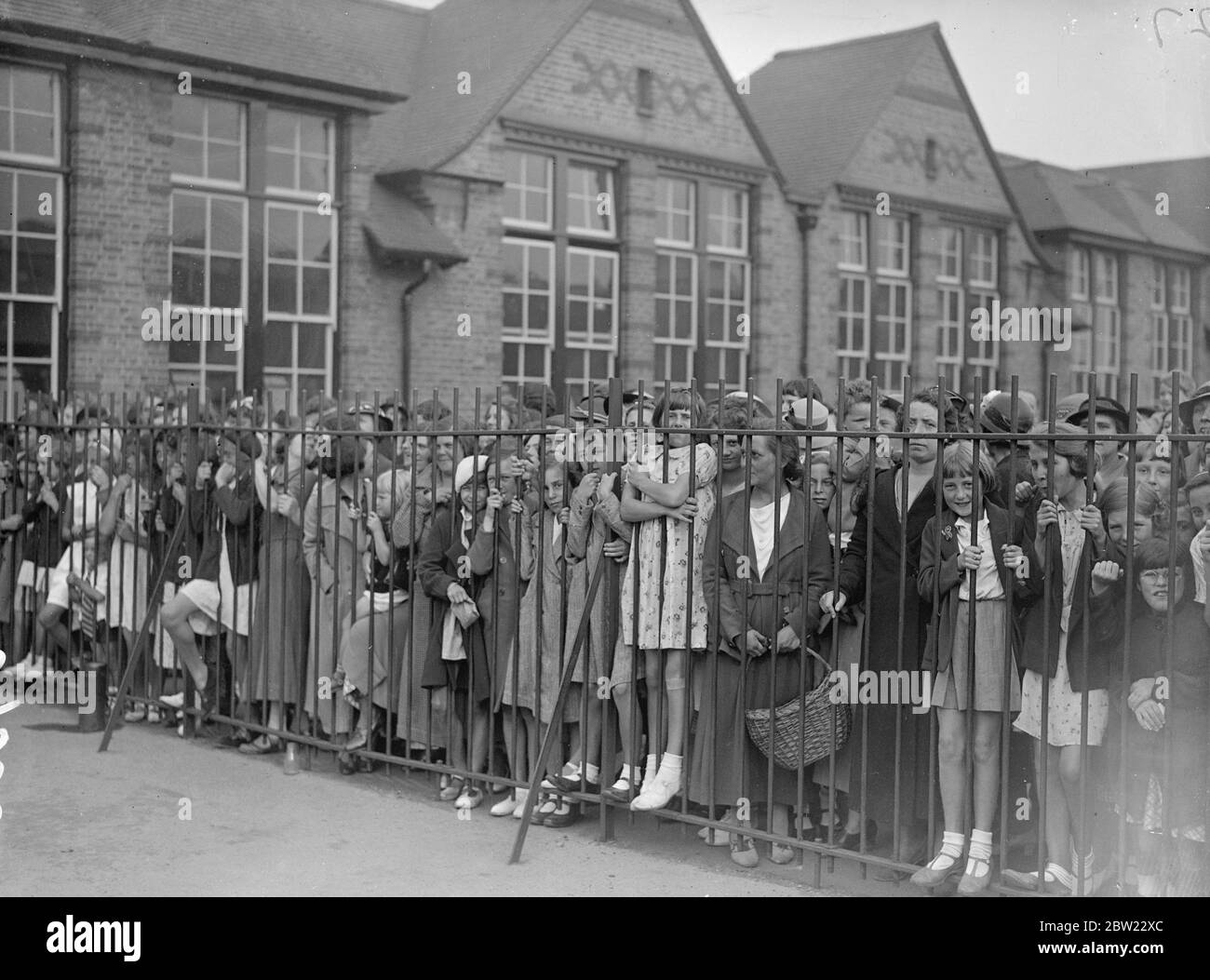 Centinaia di scolari sono in sciopero a Romford, Essex, come protesta di 350 genitori contro le autorità educative della contea di Essex per aver chiesto che i bambini vadano in una nuova scuola a Whale-Bone Lane, Chadwell Heath. Bambini dietro le ringhiere nel parco giochi della vecchia scuola a London Road. 30 agosto 1937 Foto Stock