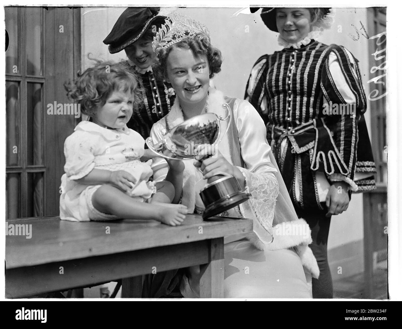 Un baby show si è tenuto alla settimana di Carnevale di Hastings. Un giovane concorrente che viene mostrato un trofeo dalla regina del Carnevale, Miss Gladys Armitage. 30 agosto 1937 Foto Stock