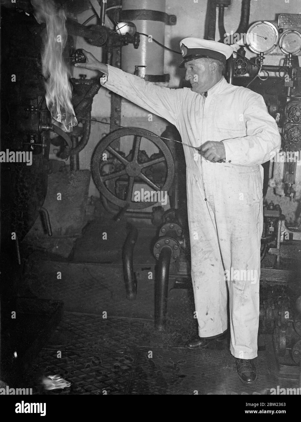 Il signor T.F Warnock il secondo ingegnere, che ha fatto lampeggiare (illuminando) le fornaci a combustione di olio della nave di ricerca reale William Scoresby che navigherà tra pochi giorni dal molo di St Catherines, Londra , nella sua nuova spedizione di marcatura dei pozzi in Antartide. La nave di ricerca segna le balene con freccette in modo che i loro movimenti attraverso gli oceani possano essere tracciati. 15 settembre 1937. Foto Stock