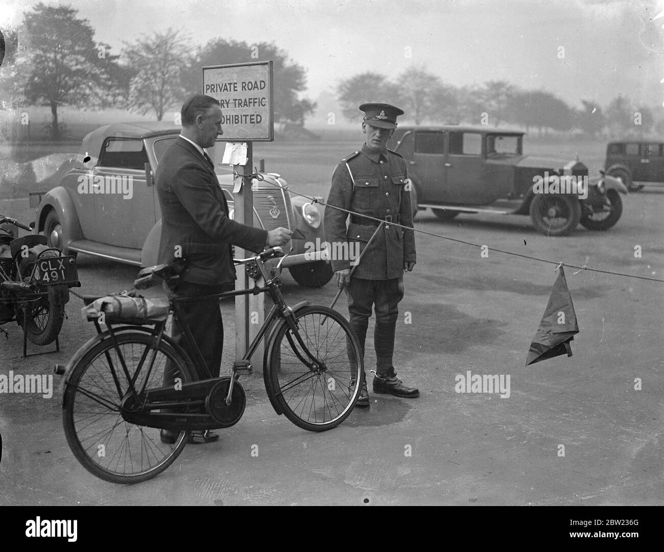 Si svolgono strade militarmente chiuse per 'perambulazione annuale' di proprietà del dipartimento di guerra. Questa azione viene intrapresa una volta all'anno per dimostrare la proprietà della proprietà. Spettacoli fotografici, ciclisti tenuti in su ad una barriera di corda e Woolwich. 21 settembre 1937 Foto Stock