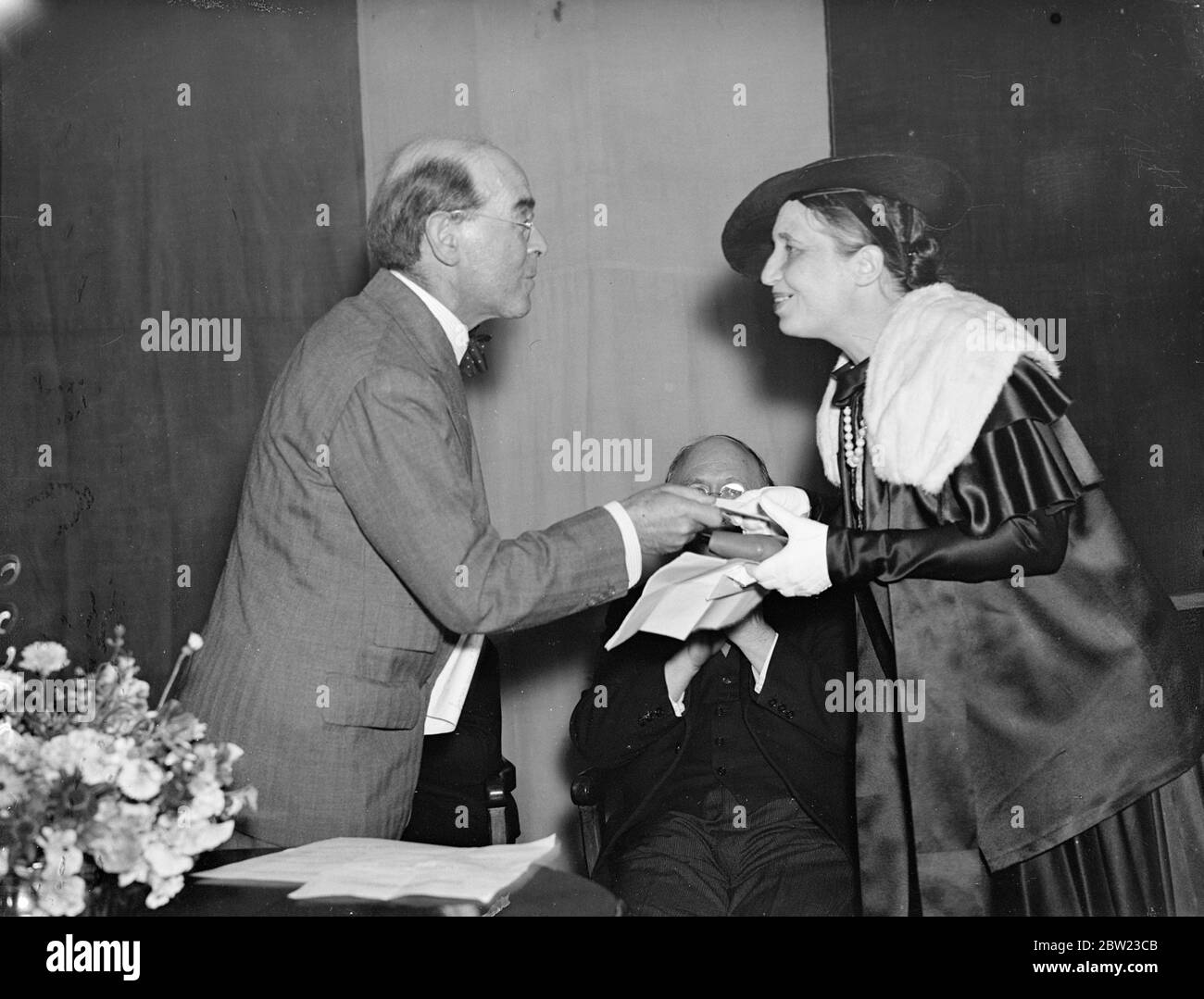 Madame Elvire Pelissier riceve il premio da Sir William Rothenstein . È la vincitrice del premio Femina vie Heureuse per il miglior lavoro di scrittura fantasiosa. 7 luglio 1937. Foto Stock