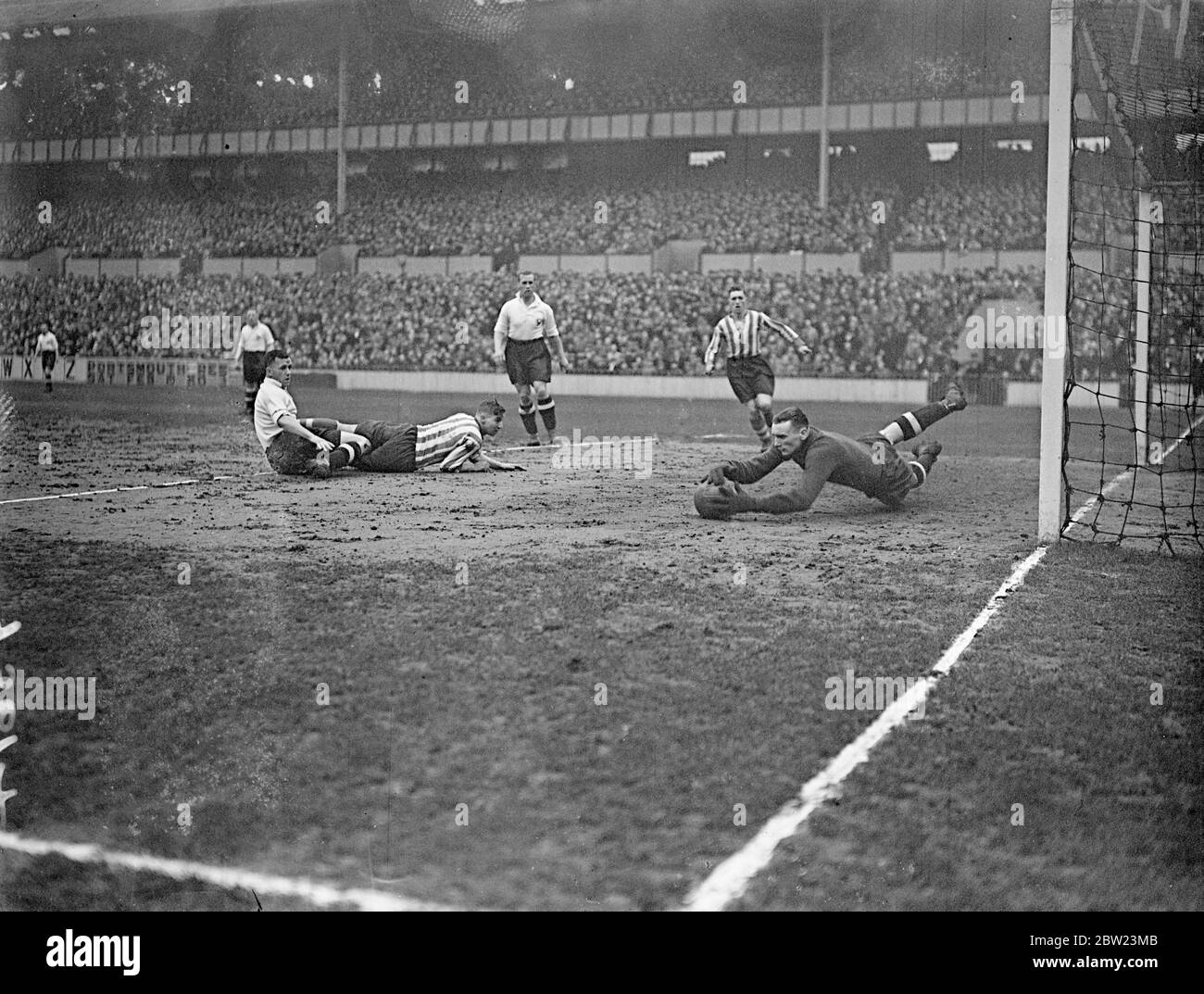 Il disperato salvataggio di Percy Hooper a Tottenham. Percy Hooper, il portiere di Tottenham Hotspur, si è gettato a tutta lunghezza per salvare in modo disperato mentre un giocatore di Spurs e Chesterfield si trova di fronte al gol durante il gioco di pareggio della Fa Cup a White Hart Lane, Londra. 16 febbraio 1938 Foto Stock