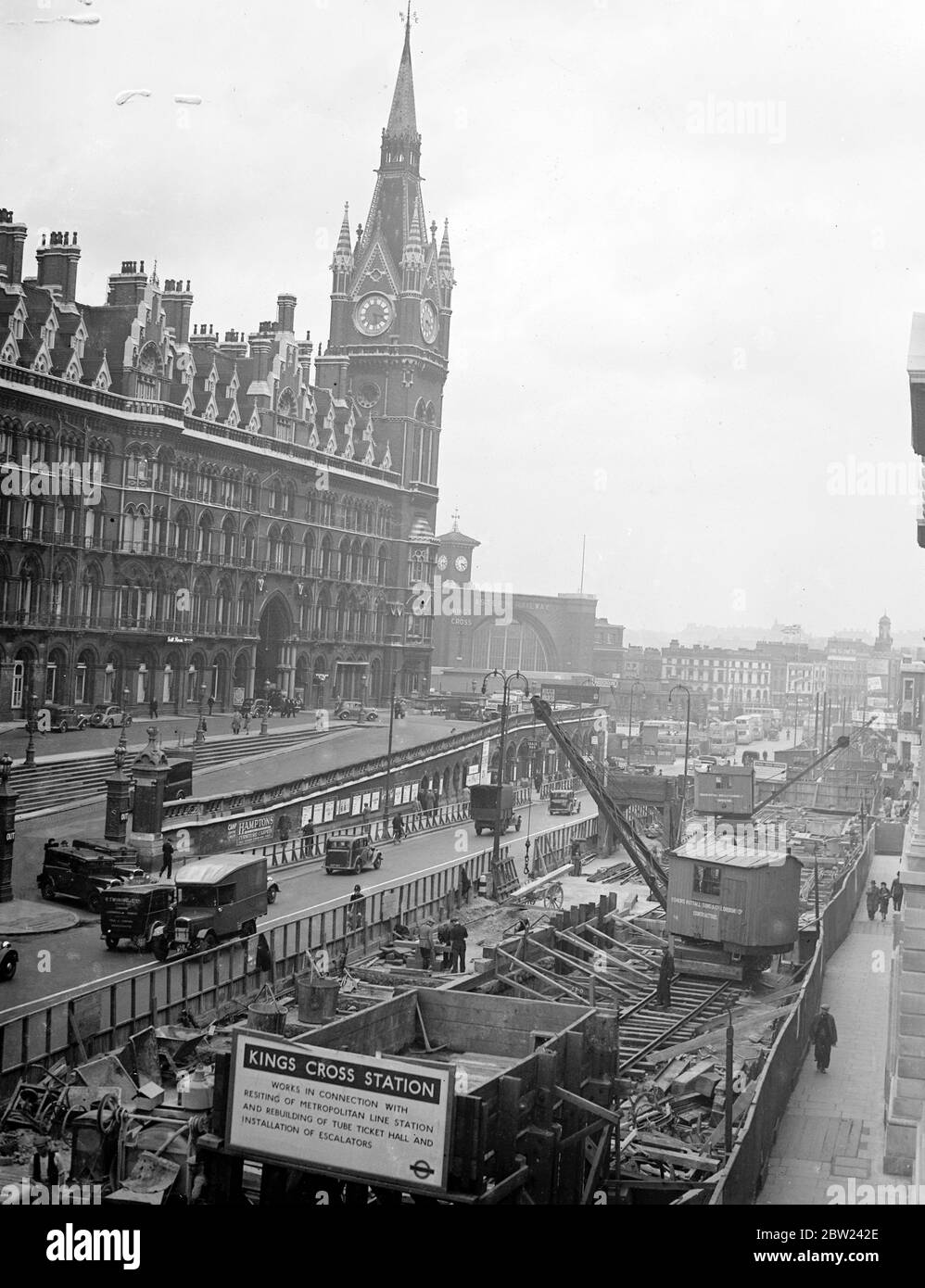 Anche se i lavoratori ferroviari di St Pancras sono in sciopero, gli uomini stanno ancora lavorando a molti piedi sotto la stazione, sulla ricostruzione della stazione della metropolitana di King's Cross. Spettacoli fotografici: Recintato in lavori di costruzione fuori dalla stazione di St Pancras. 13 ottobre 1938 Foto Stock