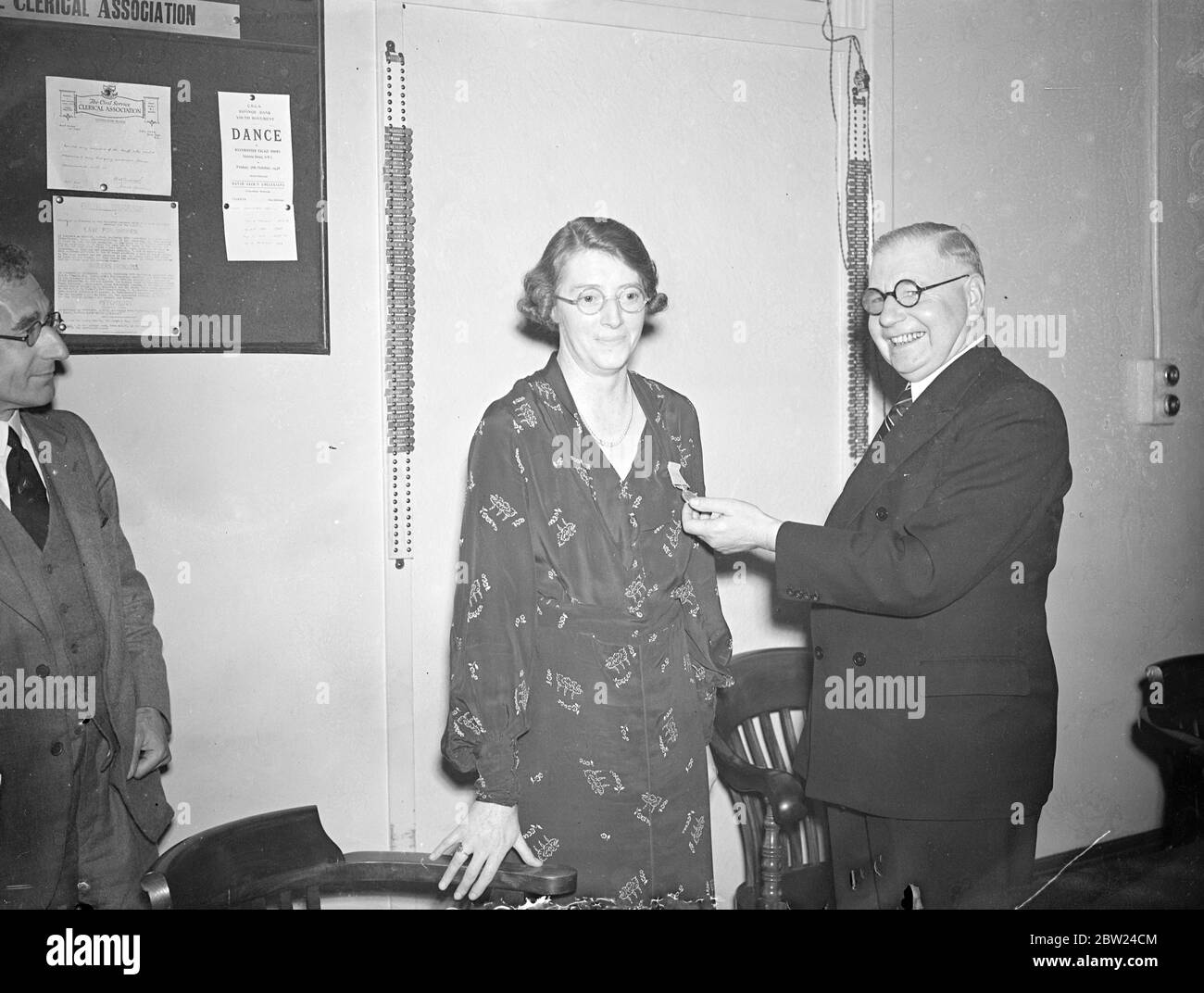 P o la banca di risparmio matron riceve la medaglia OBE. A nome del re, l'assistente Postmaster generale (Sir Walter Wormsley) ha presentato la medaglia dell'Ordine dell'Impero britannico a Miss Kathleen Roche, la matrona del personale della banca di risparmio della posta a West Kensington, Londra. Foto, Sir Walter Wormsley che si è pentito della medaglia di Miss Kathleen Roche. 19 settembre 1938 Foto Stock