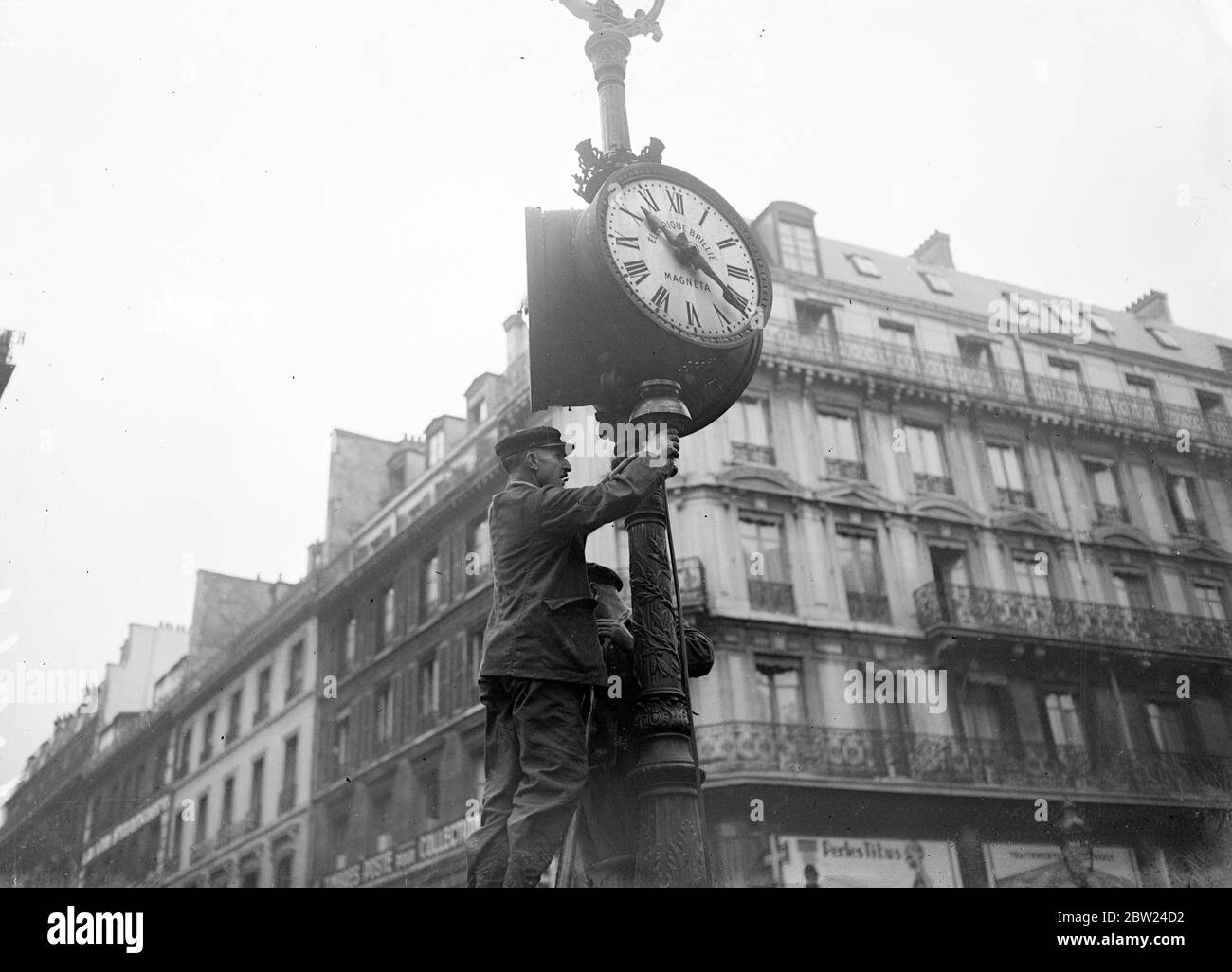 Parigi Dims lampioni come precauzione Air raid. Parigi, la città della luce, ha le sue luci di strada dotate di schermi blu come misura precauzionale contro le incursioni aeree. Foto mostra, un operai che montano uno scudo alle lampioni a Parigi. 25 settembre 1938 Foto Stock