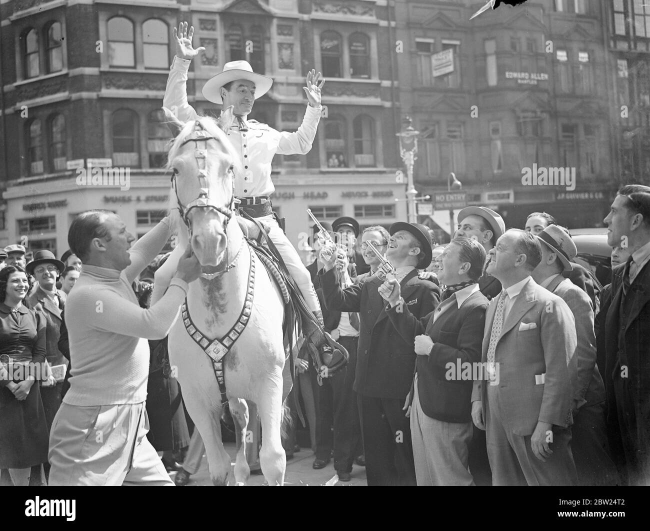 Tom Mix, attraversa il West End su Tony. Tom Mix, l'attore del film dei cowboy, ha creato una diversione nel West End occupato cavalcando il suo cavallo Tony il secondo attraverso il traffico. Spettacoli fotografici, Tom Mix tenuto dal Palladium 'Crazy Gang ' in Marlborough Street. 3 settembre 1938 Foto Stock