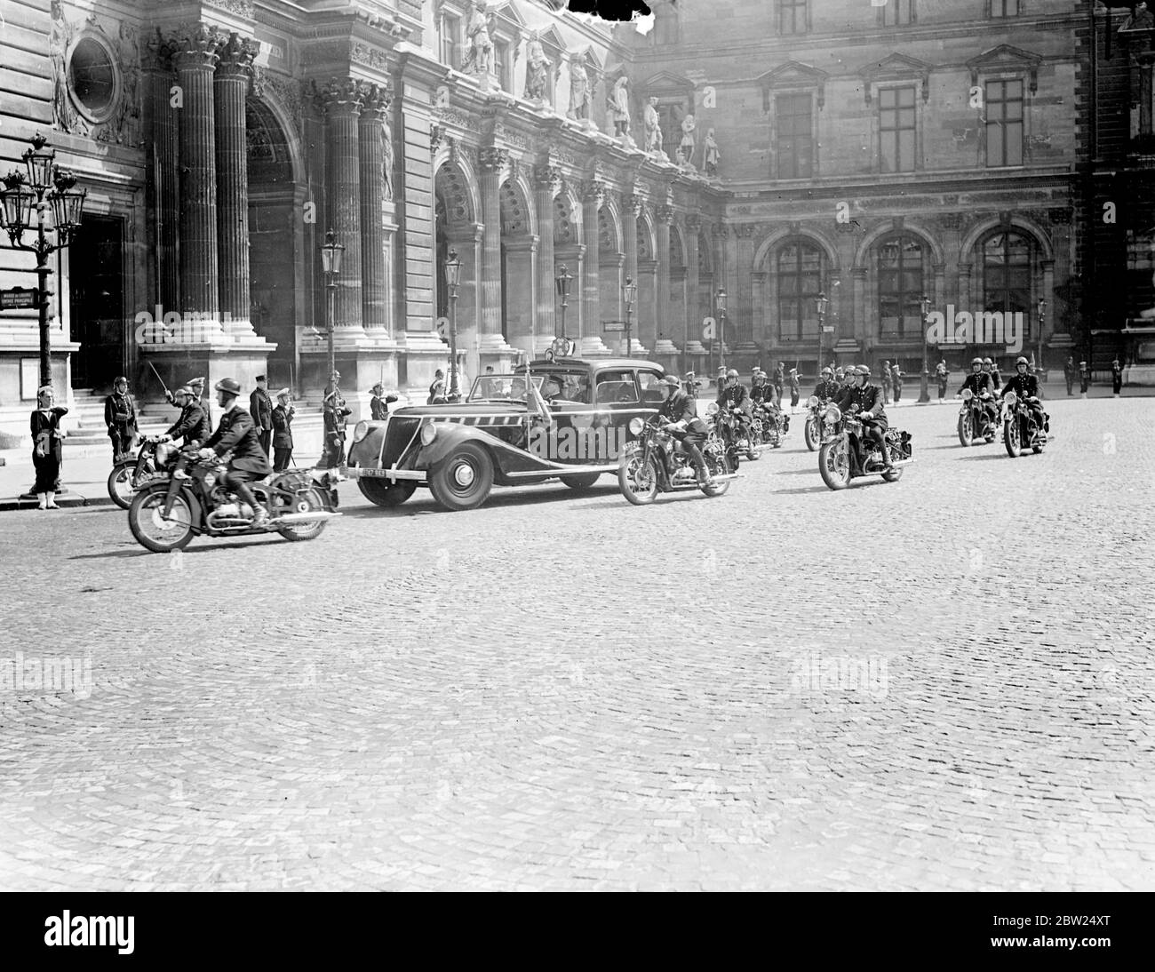 Re e Regina visitate la mostra d'arte britannica al Louvre. Guidando in un'auto vicina con una scorta di polizia motociclistica, il Re e la Regina hanno visitato l'esposizione di arte britannica al Louvre di Parigi. Erano accompagnati da Pres e Mme Lebrun. Spettacoli fotografici, il Re e la Regina che arrivano al louvre con la loro scorta. 20 luglio 1938 Foto Stock
