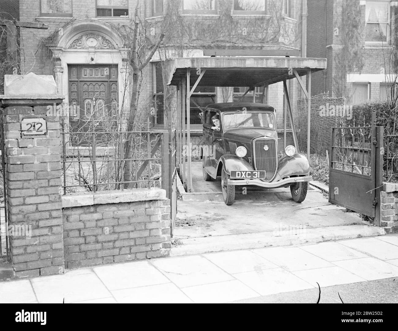 Garage 'a pulsante' sotto il giardino anteriore. L'uomo di Londra risolve il problema dei proprietari di auto. Il problema principale che si pone al conducente proprietario, quello di garage della sua auto, convenientemente e almeno a spese è stato risolto da un uomo londinese, MR R B Bourdillon di Frognal Lane, nella periferia di Hampstead. Quando arriva a casa, il signor Bourdillon guida su una lastra di cemento innocente nel suo giardino, entra nella sua casa, preme un pulsante e la scheda scende nel suo garage, una fossa di cemento impermeabile affondato nella terra. Il tetto del garage fa parte del giardino anteriore. Quando la vettura è di nuovo necessaria, un tocco Foto Stock