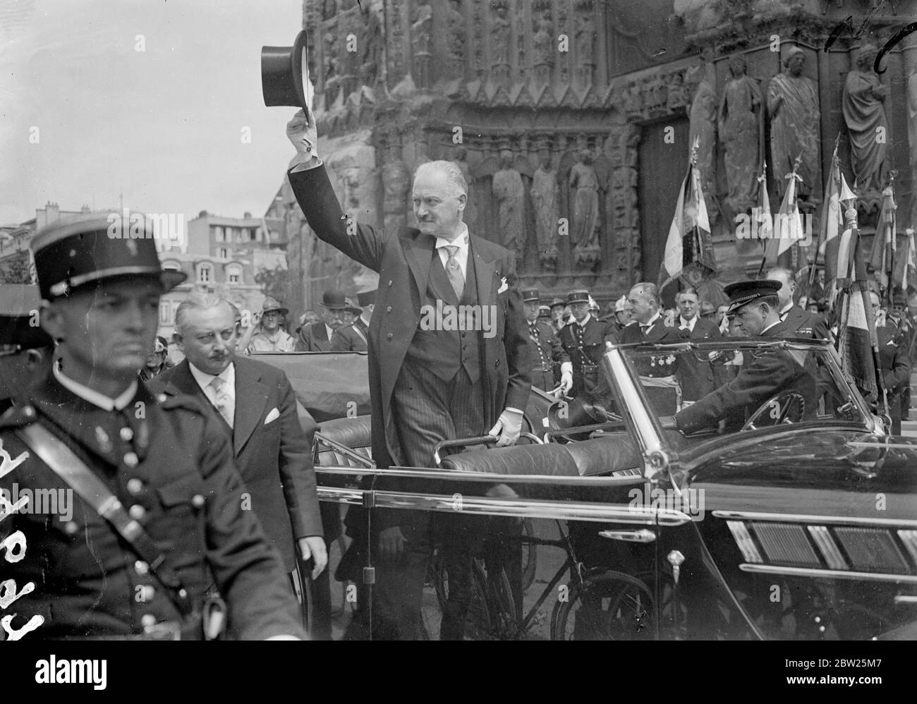 Il presidente Lebrun ondeggia il cappello all'inaugurazione della cattedrale di Reims restaurata. Il Presidente francese Lebrun era presente alla restaurata Cattedrale di Reims quando il grande edificio fu inaugurato dal Cardinale Suhard alla presenza di molti dignitari cattolici di tutto il mondo per il completamento dei lavori di ricostruzione. La Cattedrale fu danneggiata in modo severo durante la guerra. Spettacoli fotografici, il presidente Lebrun sventolando alla folla fuori dalla cattedrale di Reims dalla sua auto. 11 luglio 1938 Foto Stock