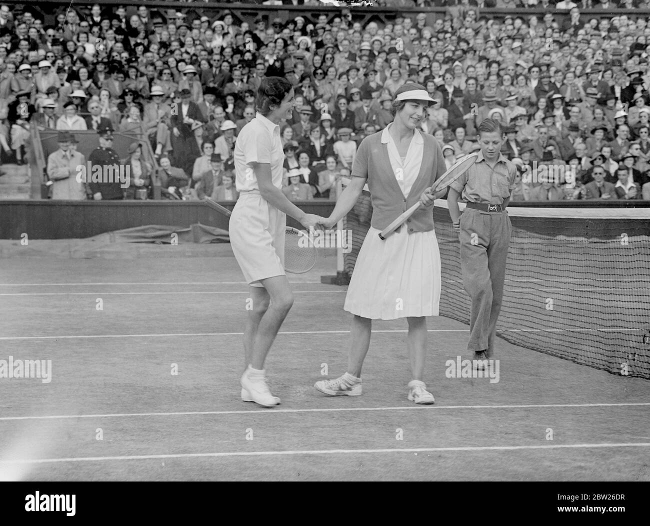Helen Wills vince la semifinale di Wimbledon, per incontrare Helen Jacobs. La signora Helen Wills Moody of America ha sconfitto la FRU S Sperling di Danimarca 12-10, 6-4 dopo una dura lotta nelle semifinali dei singoli femminili a Wimbledon, Londra. Dopo la partita era così consumata che ha preso rinfresco sotto forma di acqua in cui le polveri erano state mescolate. Spettacoli fotografici, Helen Wills si congratulava con la FRU Sperling. 30 giugno 1938 Foto Stock