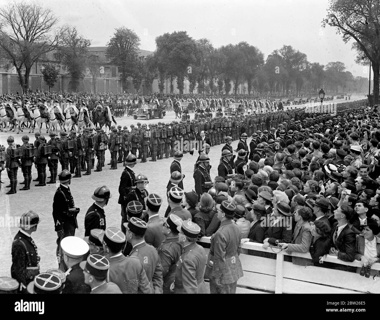 Aerei da guerra e unità meccanizzate in francese esercito revisione prima di re. Il re, accompagnato dal presidente Lebrun, ha recensito oltre 50,000 uomini dell'esercito francese, tra cui la cavalleria, le divisioni meccanizzate e coloniali, in una parata in suo onore a Versailles, Parigi. Durante una revisione 600 aerei volarono in testa. Foto mostra, l'auto del re circondato da truppe alla recensione. 21 luglio 1938 Foto Stock