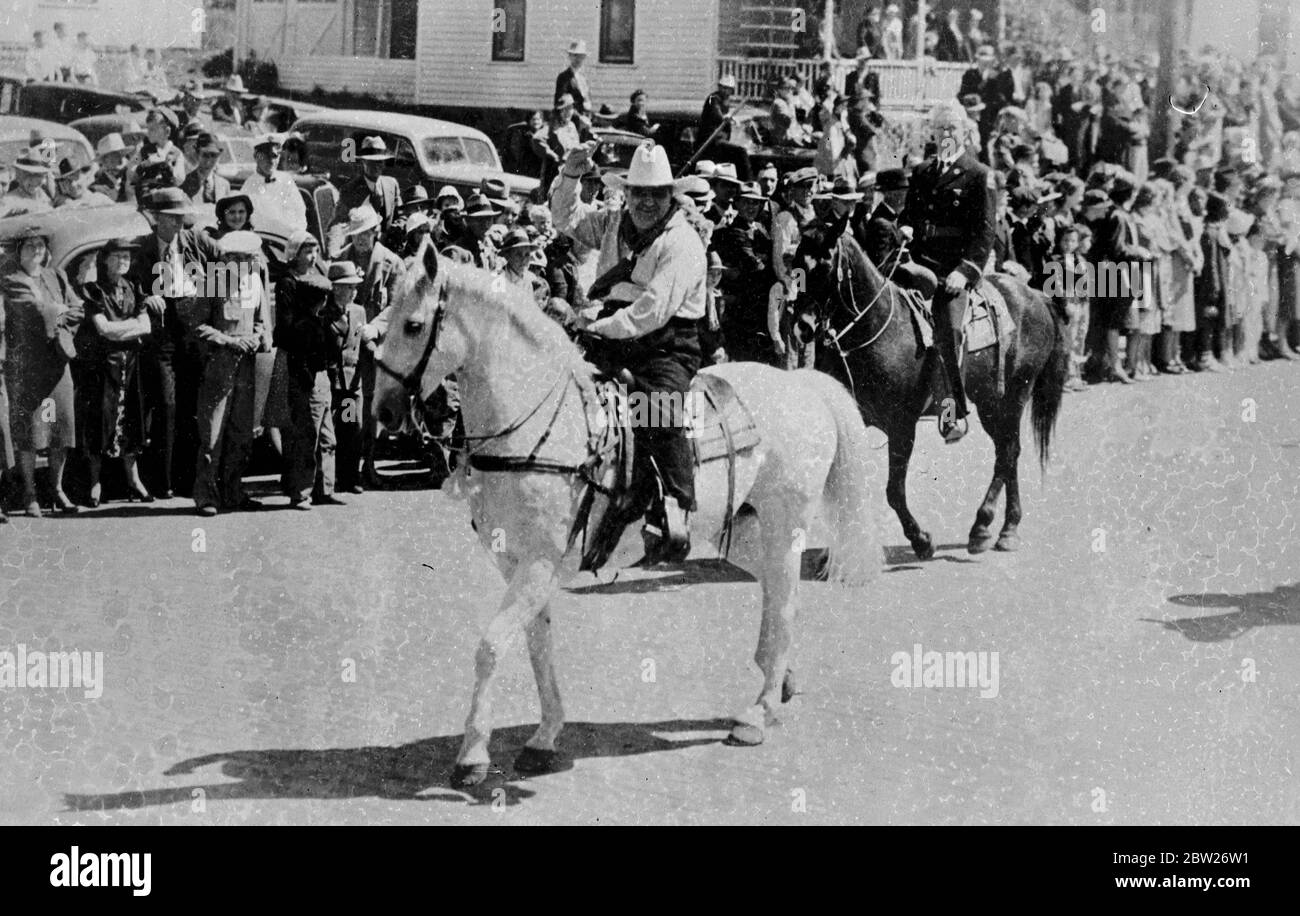 Il sindaco la Guardi va 'occidentale', conduce la sfilata a cavallo. Il sindaco Fiorello la Guardia di New York ha guidato un cavallo bianco, passando migliaia di persone che si acclamano, quando ha guidato la '89ers Parade' che ha inaugurato a Guthrie, Oklahoma, la celebrazione del 49 ° anniversario degli stati che si aprono all'insediamento bianco. 3 maggio 1938 Foto Stock