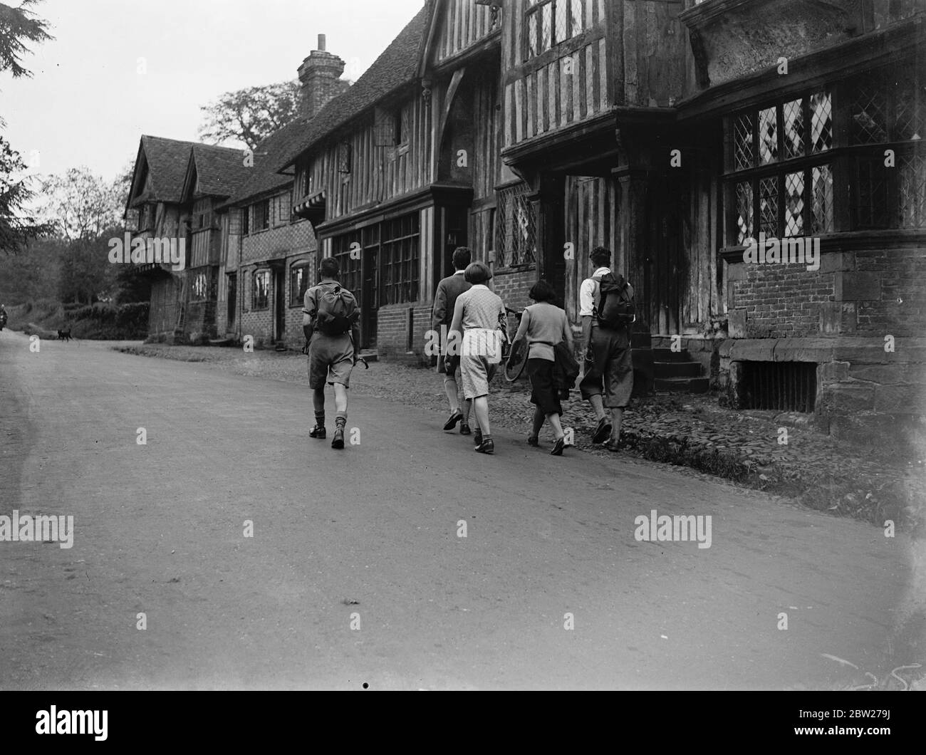 Escursionisti che attraversano il villaggio di Chiddingstone, Kent. 1933 Foto Stock