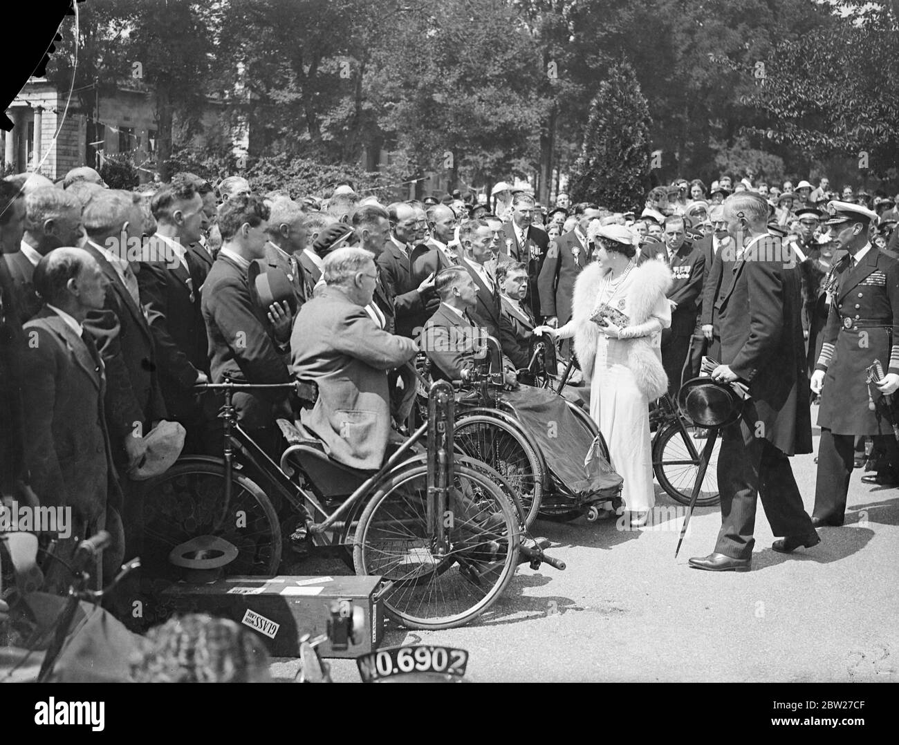 Il Re e la Regina ispezionarono ex-servi, alcuni dei quali sono paralizzati, da sette contee gallesi quando posero una corona nel Welsh National Memorial all'Alexandra Gardens Cathays Park Cardiff, durante il loro tour nel Galles del Sud. 14 luglio 1937. Foto Stock