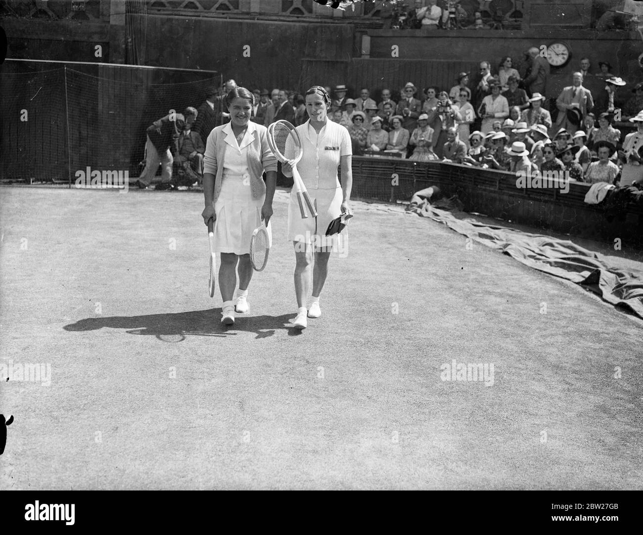 Dorothy Round e Mlle Jedrzejowska si incontrano nella finale di wimbledon. Giocando in un'ondata di caldo di luglio, la sig.ra Dorothy Round della Gran Bretagna ha incontrato Mlle J Jedrzejewska della Polonia presso il Centre Court di Wimbledon nella finale del titolo femminile di tennis. Spettacoli fotografici, Dorothy Round (a destra) e Mlle Jedrzejowska che si affacciano sul centro di Corte per la partita. 3 luglio 1937 Foto Stock