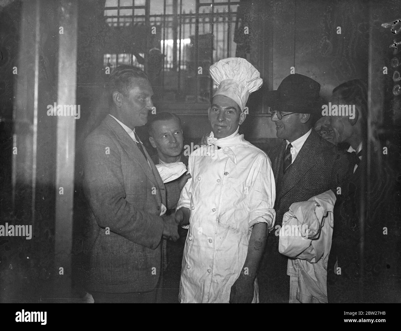 Harry Ives, uno chef della Great Western Railway, è riuscito a riportare la donna anziana e morte apparente, superata dal caldo, su un treno speciale per escursioni express da Paddington a Weston-super-Mare. La donna crollò quando il treno arrivò a Weston e il signor Ives, esperto di massaggio, la ravvivò massaggiando il cuore. Il sig. Harry Ives si è congratulato per il suo ritorno alla stazione di Paddington. 19 luglio 1937 Foto Stock