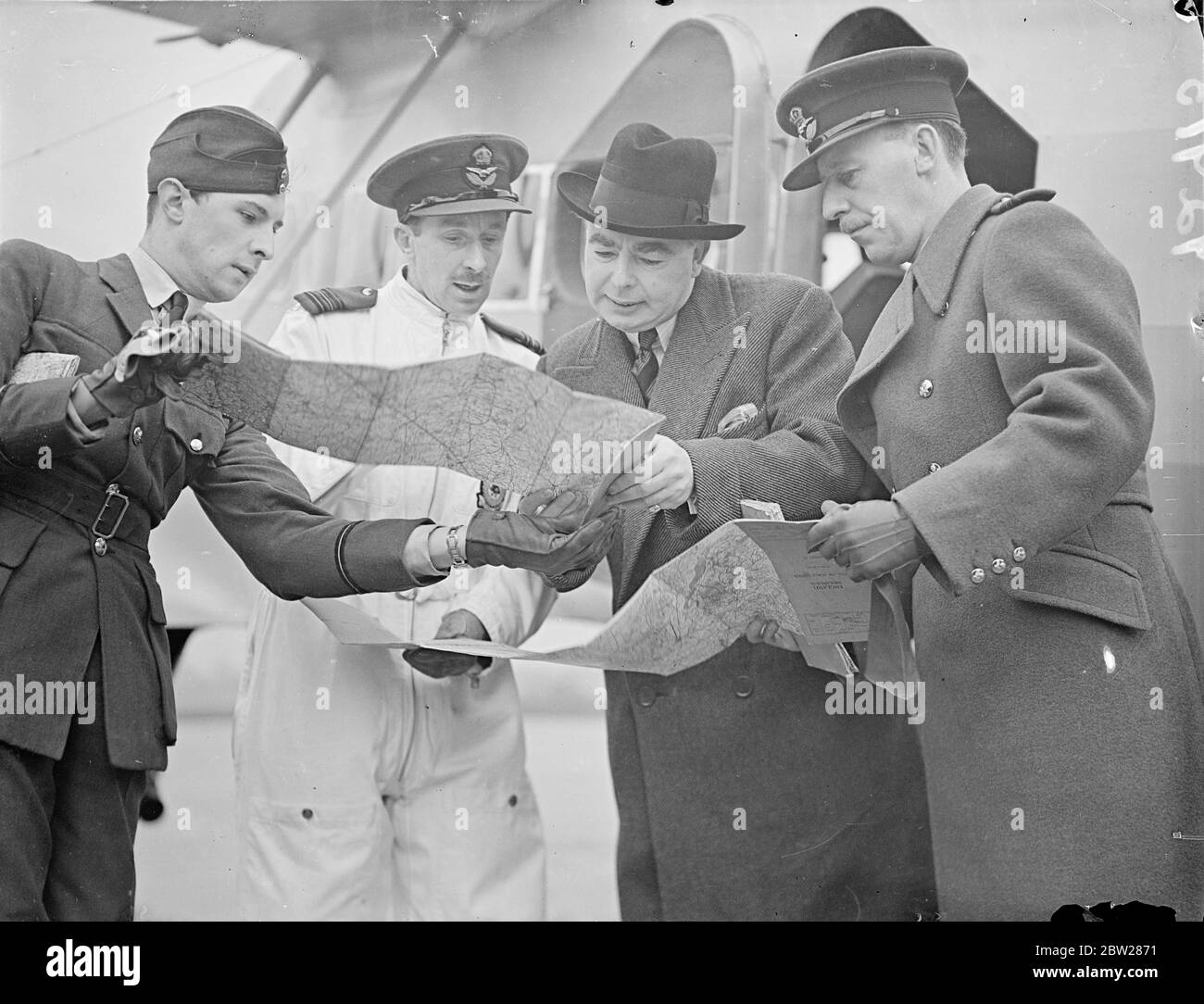 Hore Beliha , lascia l'Aerodromo di Hendon per Ulster. Leslie Hore Belisha, ministro della guerra, ha lasciato l'Aerodromo reale dell'aviazione di Hendon per una visita di ispezione nel distretto dell'Irlanda del Nord. Sarà ospite di Lord e Lady Londonderry a Monntstewart durante il suo soggiorno. Spettacoli fotografici, Leslie Hore Beliha, studiando la rotta aerea per l'Irlanda del Nord, con lo Squadron leader Goode (in bianco) prima di decolli da Hendon. 12 gennaio 1938 Foto Stock