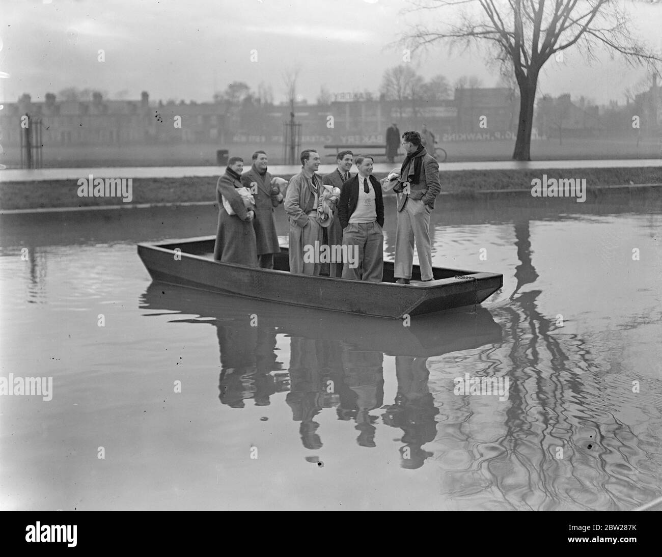 Gli equipaggi di Cambridge prendono il traghetto per esercitarsi. Quattro mesi prima della gara in barca del 2 aprile, gli equipaggi di Cambridge hanno iniziato un serio allenamento sul River Cam di Cambridge, dove si eserciteranno fino a marzo, prima di trasferirsi sul Tamigi. Spettacoli fotografici, orsman di Cambridge che attraversa la camma in traghetto per la pratica. 5 gennaio 1938 Foto Stock