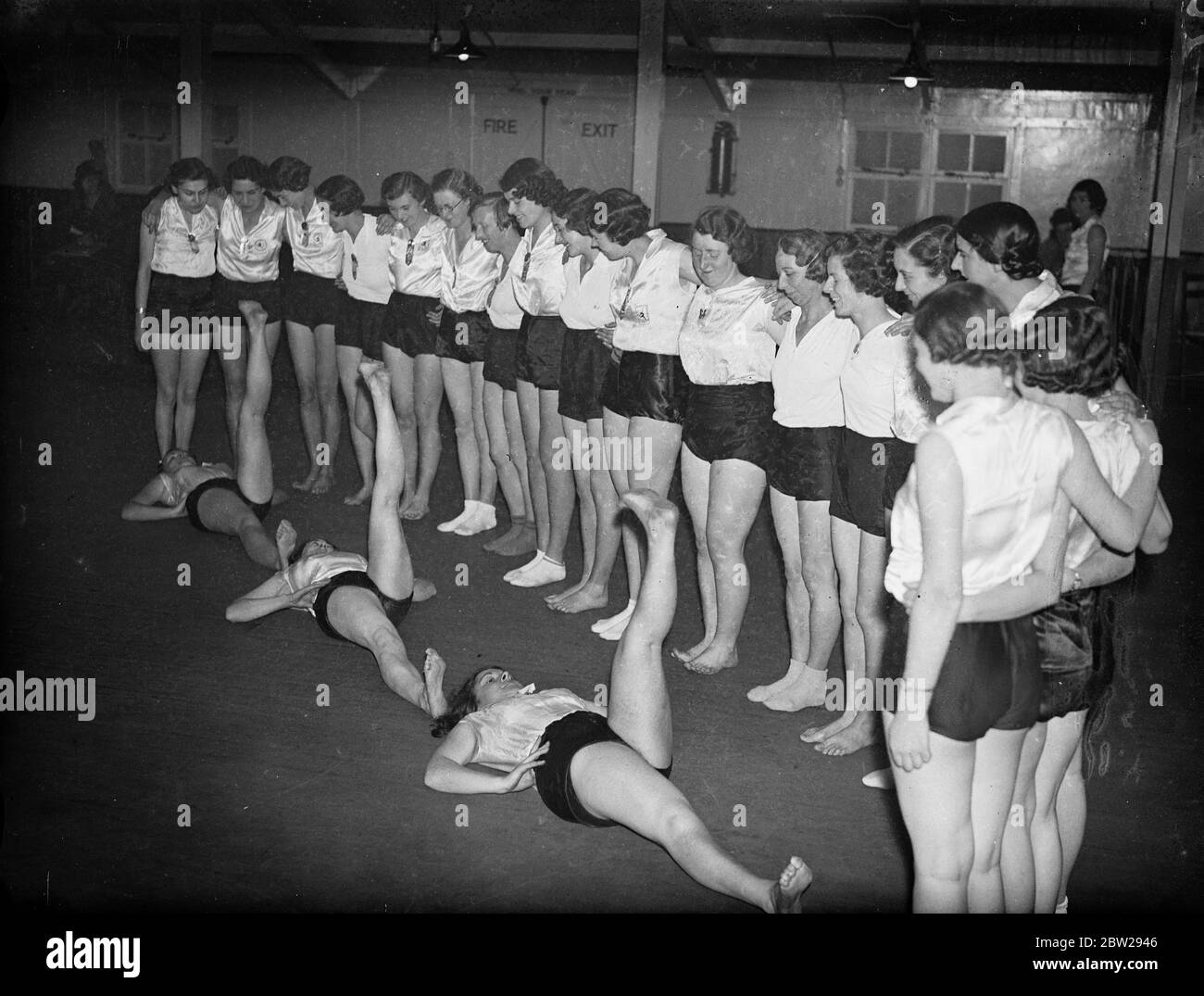 Le ragazze ferroviarie trovano un modo permanente per la salute. I lavoratori della Great Western Railway che guardano tre dei loro compagni eseguono uno degli esercizi della classe 'Keep Fit'. Cento ragazze frequentano regolarmente le lezioni allo Stanley Street Institute di Paddington London. 2 dicembre 1937 Foto Stock