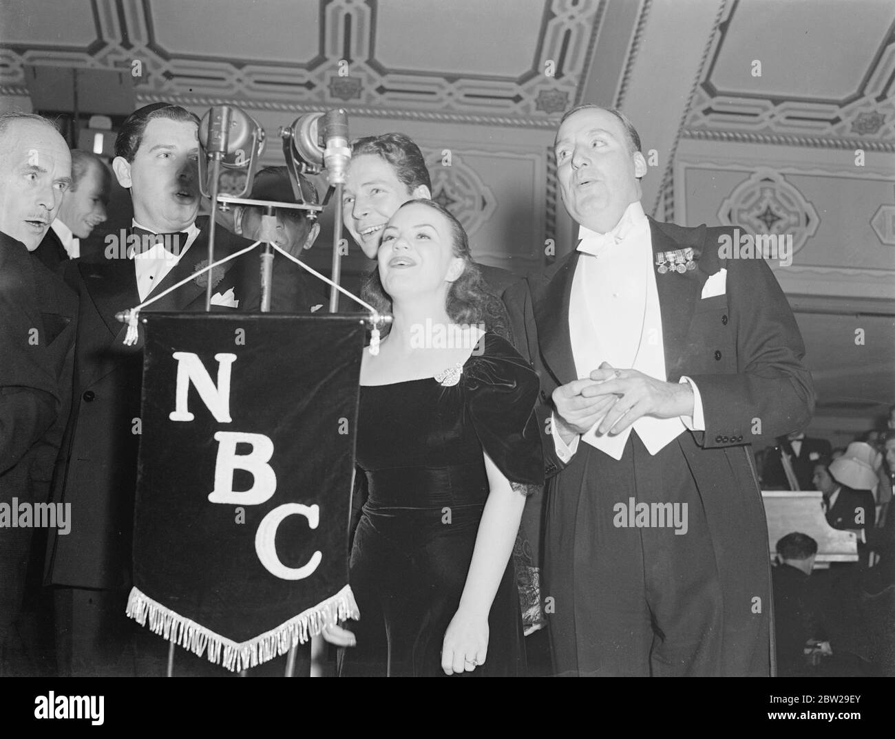 Da sinistra a destra, Jimmy Gleason, Milton Berle (dietro il microfono), Kenny Baker, Ella Logan e Alan Mowbray. Foto Stock