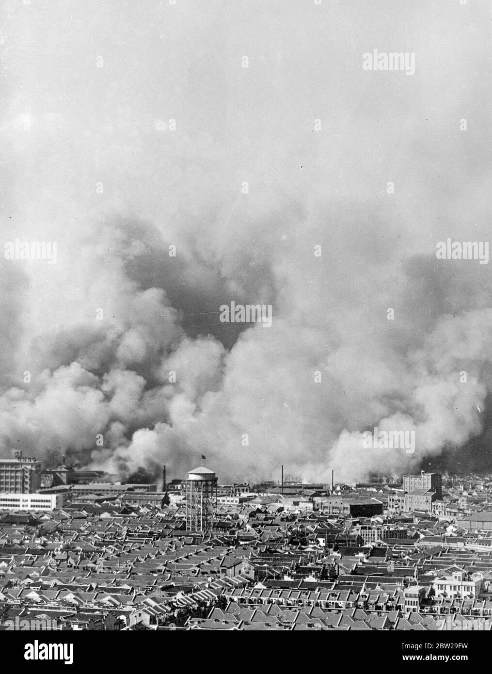 Teme pioggia più che conchiglie. Tenere asciutto sul fronte di Shanghai. L'allarme ambra sembra una strana aggiunta alla divisa dei soldati in tempo di guerra, ma questo secolo cinese lo ha trovato utile sul fronte di Shanghai, dove le piogge incessanti lo hanno reso necessario. I cinesi sono stati spesso deridati come 'soldati del tempo delle favole' e l'ombrello potrebbe sembrare per sopportare la disputa negli occhi occidentali. Ma la maggior parte delle truppe che ora combattono i giapponesi sono irregolari e sono mal attrezzate per le condizioni meteorologiche del fronte. L'ombrello, leggero e facilmente trasportabile, serve a mantenere il soldato e la sua attrezzatura modesti Foto Stock