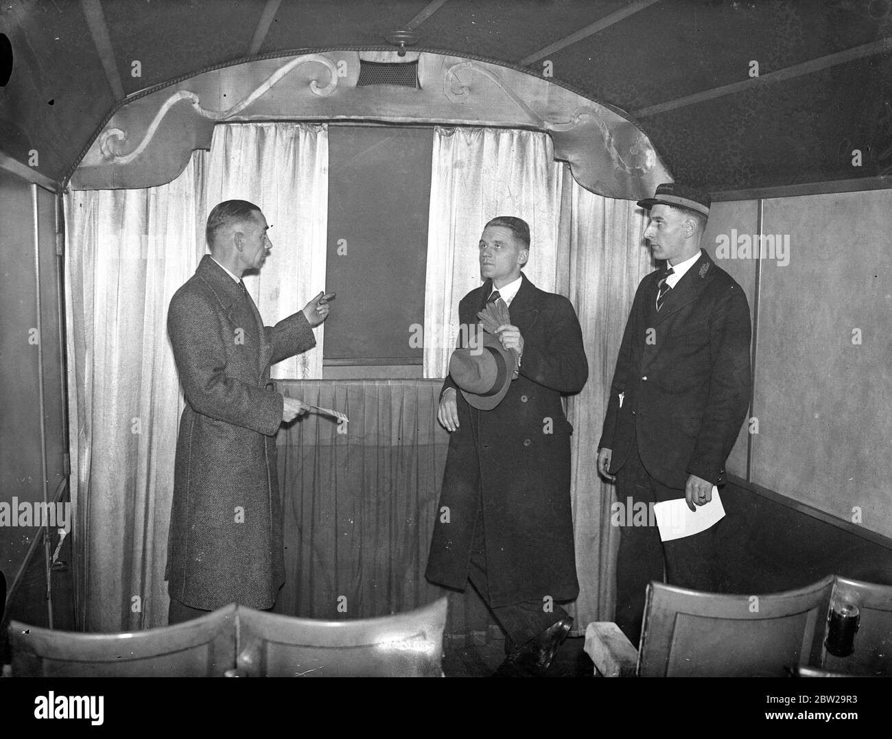 Il regista tedesco vede il cinetreno britannico. Herr Muller Hillebrand, responsabile del dipartimento cinematografico tedesco delle ferrovie, invitato a mostrare alcuni film ai funzionari delle ferrovie britanniche, ha visitato King's Cross Station, Londra, e ha ispezionato lo speciale allenatore cinematografico. Questo pullman è dotato di un cinema in miniatura. Spettacoli fotografici, Herr Muller Hillebrand (centro), che viene mostrato presso il pullman del cinema a King's Cross. 27 novembre 1937 Foto Stock