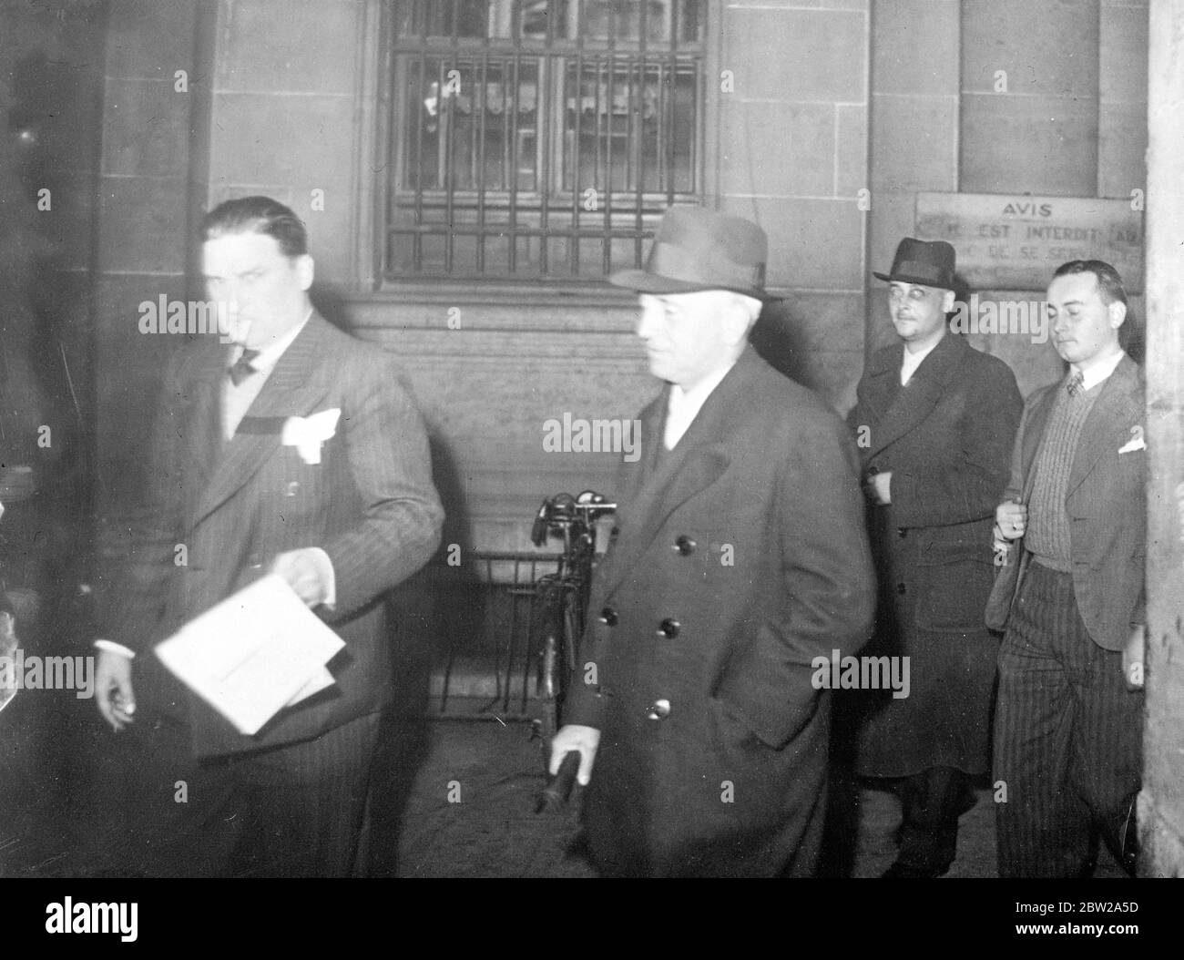 Ex ufficiale navale e segretario arrestato nel complotto 'Cagoulard'. M Lemaresquier, ex capitano navale nipote di ADML le Bigot, attacca a nella famiglia militare del defunto presidente Doumer, è stato arrestato dalla polizia francese in relazione al sensazionale complotto 'Cagoulard' (uomini cowled). Anche il segretario, Mme Berthelot, è stato arrestato. In una dichiarazione ufficiale, M Donmoy, ministro degli interni, ha rivelato che i 'plotters miravano al rovesciamento delle istituzioni repubblicane prima di procedere al restauro della monarchia'. Spettacoli fotografici, M Lemaresquier (centro, cappello morbido) dopo il suo Arr Foto Stock