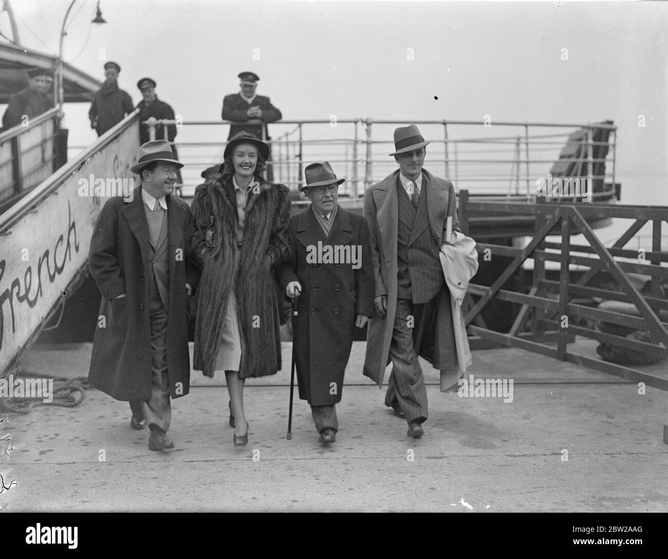 Frank McHugh conduce l'invasione di Hollywood all'arrivo a Southampton. Guidato da Frank e McHugh, il comico, molte persone famose nel mondo del cinema hollywoodiano, arrivò a Southampton a bordo della 'Normandie'd'America. Spettacoli fotografici, da destra a sinistra, Frank McHugh, Max Factor, l'esperto di bellezza e make-up di Hollywood, Sandra Storm, l'attrice del film, e Philip Holmes, attore britannico all'arrivo a Southampton. 15 novembre 1937 Foto Stock