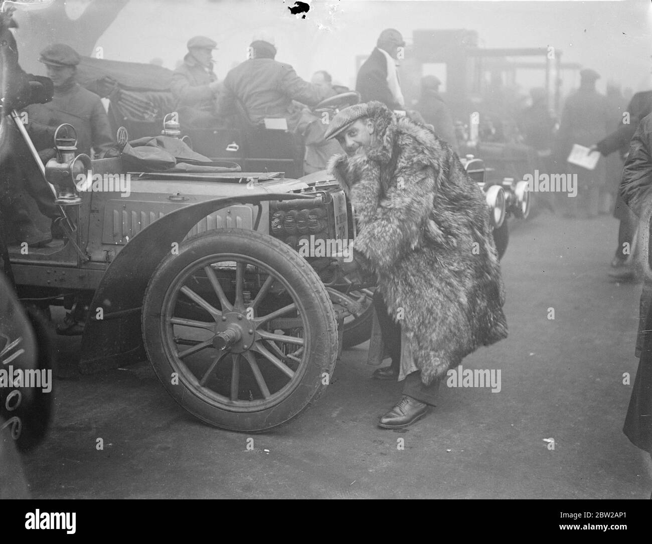 Ha preso una punta dai vecchi-timers!. La corsa annuale dell'automobile a Brighton comincia nella nebbia. In auto aperte e guidando in nebbia fitta, gli automobilisti hanno iniziato dalla rivista di Hyde Park, Londra, il 41° Commemoration Run annuale a Brighton. La corsa alla quale ha preso parte 116 vetture, ognuna di almeno 33 anni, celebra l'emancipazione degli automobilisti. Prima del 1896. Ogni veicolo a motore doveva essere preceduto da un uomo con bandiera rossa. Foto mostra, ricordando i giorni in cui gli auto-iniziatori erano sconosciuti . Il signor de Caritat, indossando un pesante cappotto di pelliccia, inizia il signor G e C Martins 1902 Dietrich in cui ha wa Foto Stock