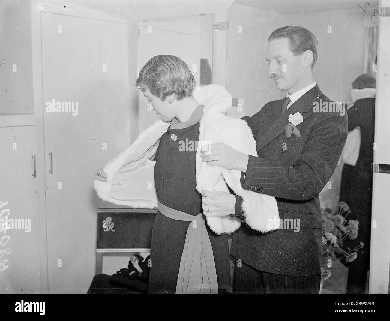 Irish peer è esperto di moda Mayfair. Discendente degli antichi re irlandesi, un collega, Lord Inchiquin, è in affari a Mayfair come un ulteriore e esperto di moda sotto il nome democratico irlandese, 'D o'Brien'His nome di famiglia. Nel suo salone Mayfair, la sedia utilizzata dai clienti è quella occupata da Lady Inchiquin all'incoronazione. Spettacoli fotografici, Lord Inchiquin che si adatta a un coatee cinese bianco di coniglio al suo salone Mayfair. Sullo sfondo è la sedia occupata da Lady Inchiquin all'incoronazione. 18 ottobre 1937 Foto Stock