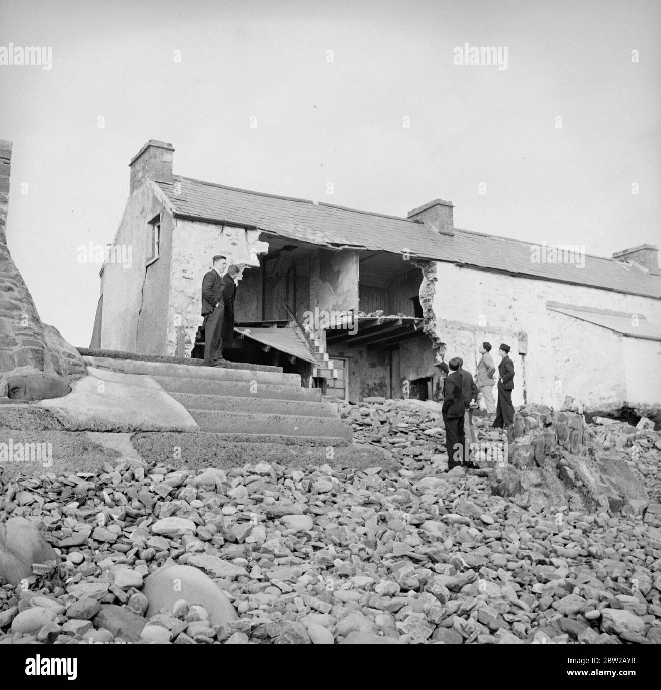 Alcuni abitanti del villaggio nella minacciata Amreth, sulla costa di Pembrokeshire, nel Galles, hanno dato il via alla battaglia contro l'Atlantico e sono stati costretti a lasciare le loro case in mare. Martoriati da alte maree primaverili, diversi cottage di fronte all'Atlantico sono stati distrutte e i loro proprietari costretti a lasciare le loro case. Gli abitanti del villaggio hanno rinforzato il muro di mare nel tentativo di evitare che le onde scoppiino e spazzino via il villaggio. Foto mostra case in rovina, con masse di ciottoli colmo contro i resti delle pareti. 6 febbraio 1939 Foto Stock