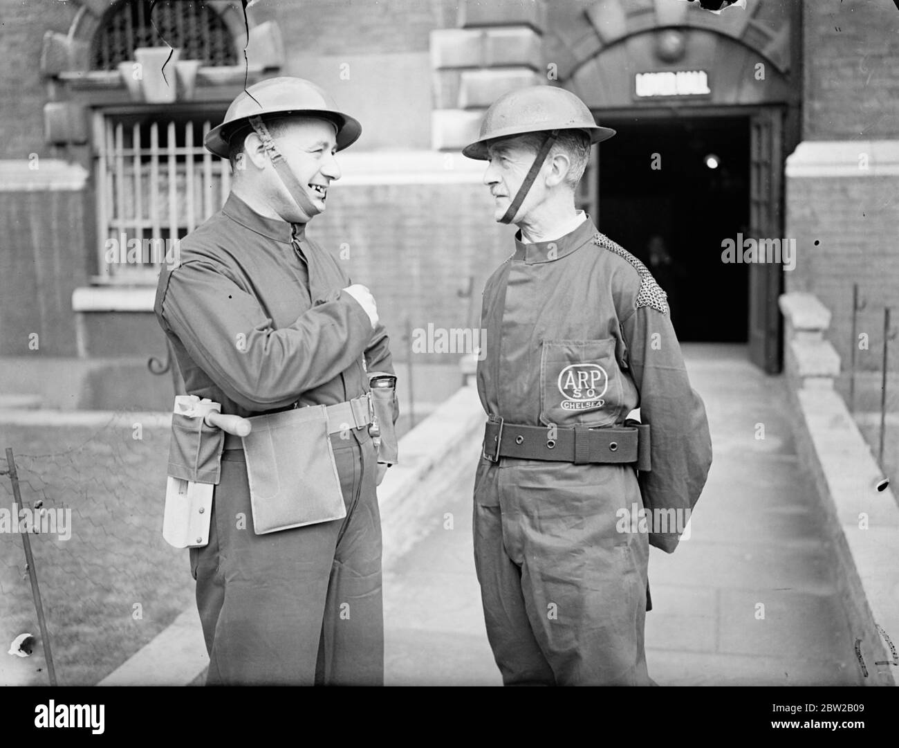 La delusione è stata causata a Chelsea dalla decisione dell'ufficio domestico di non permettere ai volontari del distretto di Air RAID Precauzioni di indossare le loro divise brune e blu intelligenti con i polsini intrecciati gialli quando la revisione del re dei servizi ARP ha luogo a Hyde Park la domenica. Il motivo è che Sir John Anderson vuole che tutti i volontari siano vestiti allo stesso modo alla revisione. 500 operai ARP Chelsea sono stati rilasciati con uniformi marroni e 200 uniformi in blu sono state emesse ad altre sezioni. Le uniformi sono del tipo generale e gli anelli intrecciati gialli sui polsini sono indossati secondo il rango. P Foto Stock