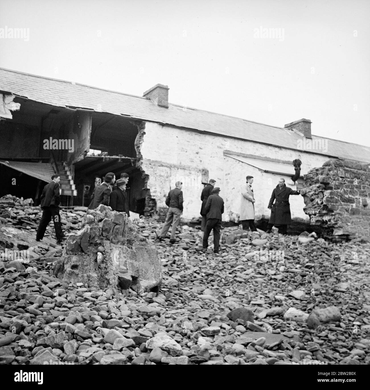 Alcuni abitanti del villaggio nella minacciata Amreth, sulla costa di Pembrokeshire, nel Galles, hanno dato il via alla battaglia contro l'Atlantico e sono stati costretti a lasciare le loro case in mare. Martoriati da alte maree primaverili, diversi cottage di fronte all'Atlantico sono stati distrutte e i loro proprietari costretti a lasciare le loro case. Gli abitanti del villaggio hanno rinforzato il muro di mare nel tentativo di evitare che le onde scoppiino e spazzino via il villaggio. Foto mostra case in rovina, con masse di ciottoli colmo contro i resti delle pareti. 6 febbraio 1939 Foto Stock