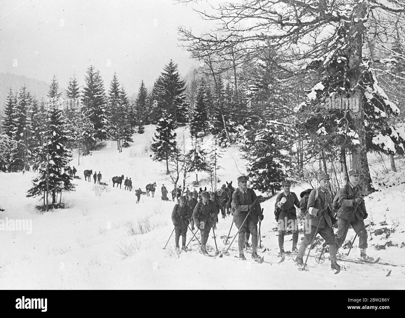 Esercito tedesco sulle manovre invernali. Truppe barvariche sugli sci con una leggera colonna di muli che passa attraverso il paese montano. 12 febbraio 1931 Foto Stock