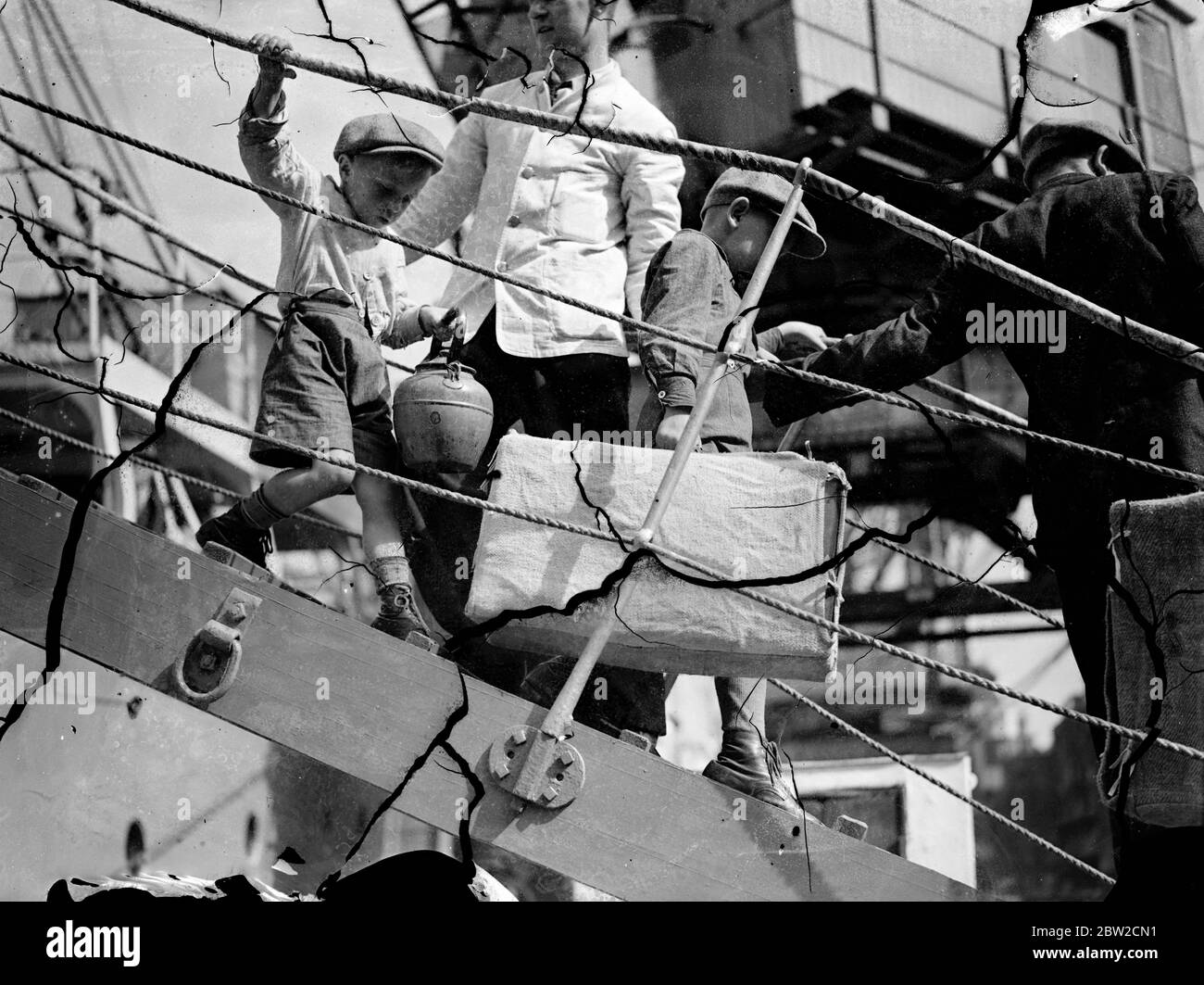 Gli emigranti polacchi in viaggio verso il Canada sbarcarono dalle SS Warszawa a Mark Brown's Wharf, Tooley Street, Londra. Un piccolo ragazzo emigrante che scende lungo la stangplank della nave con un grande bollitore. 29 agosto 1939 Foto Stock