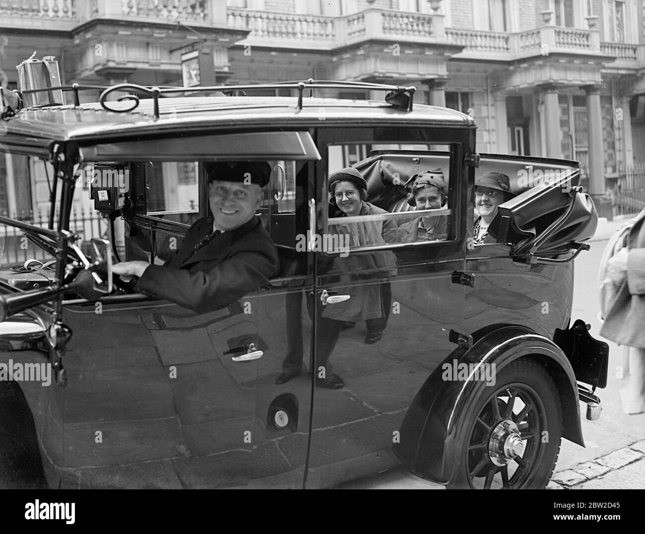 George William Owen, tassista di Hornsey, Londra, ha iniziato un viaggio di 3000 miglia; sta prendendo la signora Jolly, una donna neozelandese e le sue due figlie Rose (19) e Violet (17) in un tour di tre settimane in Inghilterra, Galles e Scozia. Due anni fa Owen ha preso un pasto informale, un signor Runciman, anche un neozelandese, che ha noleggiato il suo taxi per un viaggio in Inghilterra. E' grazie alla relazione di quel viaggio che è apparsa nei documenti della Nuova Zelanda che la onorevole Jolly, la sua fiera attuale, ha avuto contatti con lui. Owen ha preso i suoi passeggeri al loro hotel a Bayswater, e ha cominciato per il co sud Foto Stock