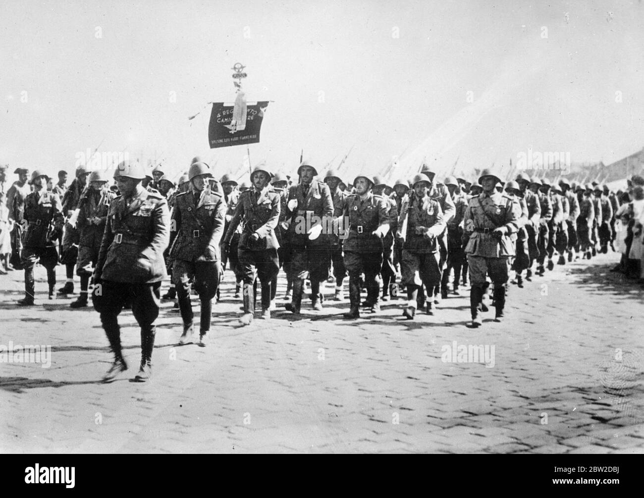 Migliaia di legionaires italiani che hanno combattuto in Spagna per il generale Franco hanno sfilato a Cadice proprio e splash ufficiali nazionalisti spagnoli prima di andare a vela per casa. 10,000 italiani sono stati ritirati dalla Spagna dal Signor Mussolini, e si pensa che questo possa dare la via all'entrata in vigore dell'accordo anglo-italiano. Foto: I legionaires italiani sfilano a Cadice mentre stavano per partire per casa. 20 ottobre 1938 Foto Stock