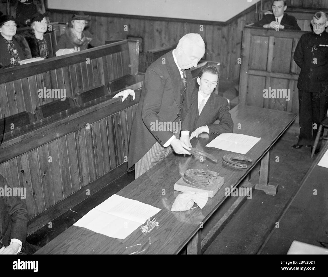 In questa cerimonia, che risale a sette secoli fa, questo Solicitor della città ha consegnato al Remembrancer del re presso il tribunale di Londra, un hatchet, un becco-hook, fagotti, ferro di cavallo e chiodi a pagamento degli affitti annuali di abbandono alla Corona per proprietà antica nello Shropshire. Pagamenti effettuati per conto della City of London Corporation. Foto: Il Solicitor della città, MR A Pickford, contando i ferro di cavallo che fanno parte del quit-rents. 19 ottobre 1938 Foto Stock
