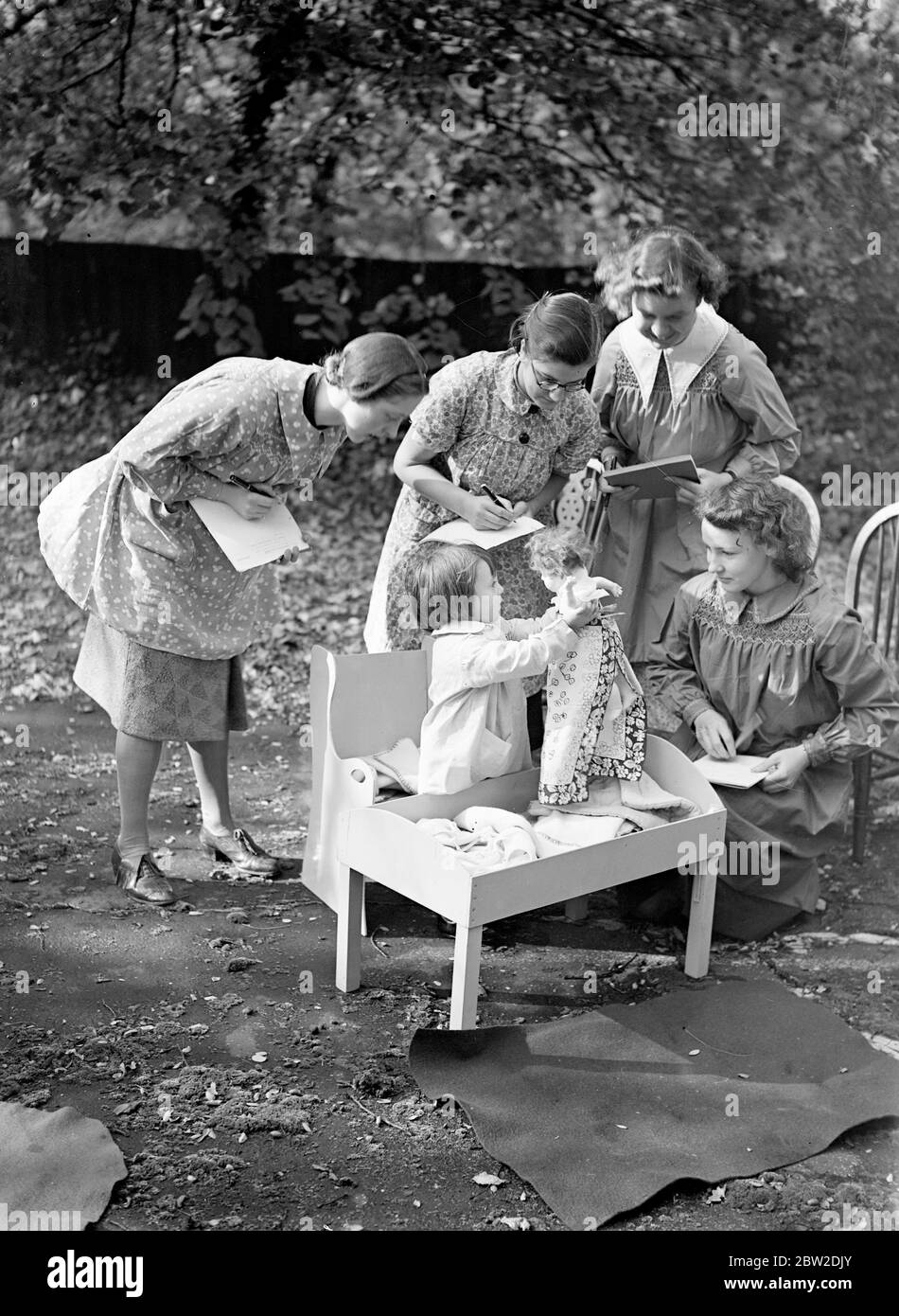 50 bambini di piccola età sotto i cinque anni presso la scuola materna romana hanno fornito esemplari di prima mano agli studenti del Gipsy Hill Training College per insegnanti di giovani bambini, Gipsy Hill, al quale è annesso. Il college è stato il primo in Gran Bretagna ad intraprendere la formazione di insegnanti per le scuole materne. I bambini della scuola materna possono fare il bagno di un bambino, usare le maniere corrette della tabella e cucinare. Essi devono dare una mostra davanti alla Duchessa di Kent in città il 10 novembre per aiutare a raccogliere i soldi per il collegio. Foto mostra: Studenti del college studiando le reazioni di un bambino che lo mette Foto Stock