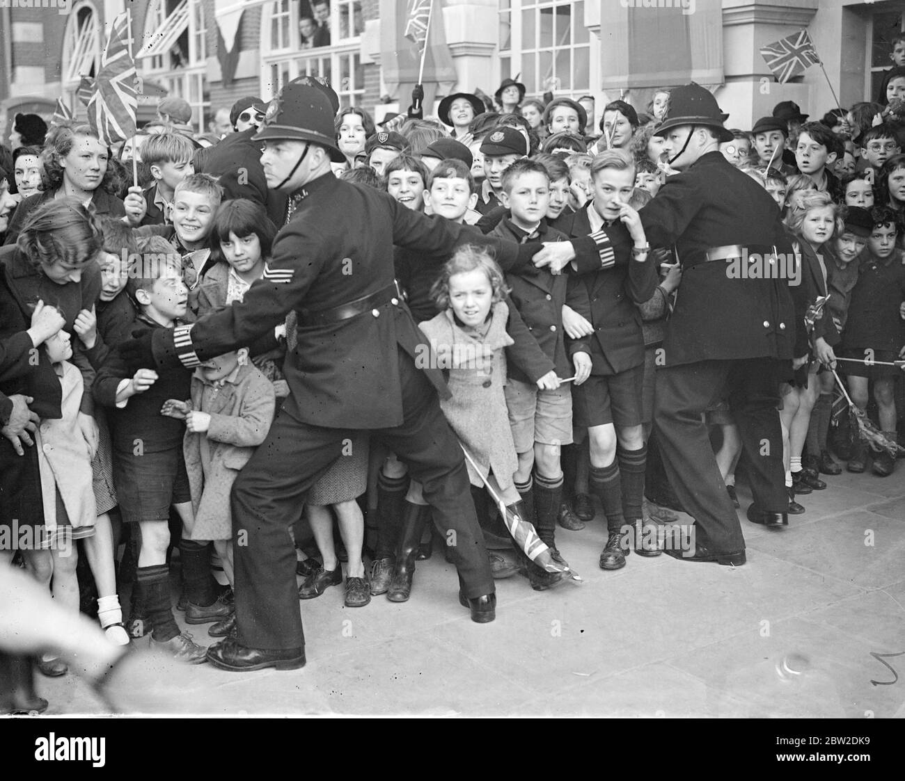 1200 bambini, provenienti da più di 100 scuole, erano tra le grandi folle che hanno salutato la Regina Maria quando ha aperto la nuova estensione del Â£90,000 al Lambeth Town Hall, Brixton. Foto: Un poliziotto che controlla la folla di bambini eccitati. 14 ottobre 1938 Foto Stock
