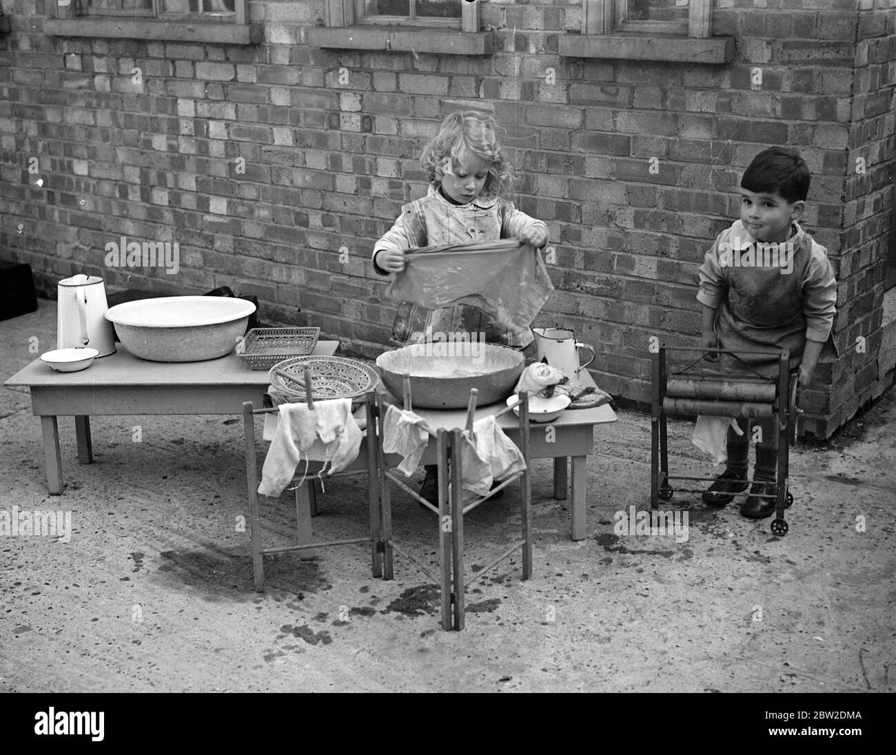 50 bambini di piccola età sotto i cinque anni presso la scuola materna romana hanno fornito esemplari di prima mano agli studenti del Gipsy Hill Training College per insegnanti di giovani bambini, Gipsy Hill, al quale è annesso. Il college è stato il primo in Gran Bretagna ad intraprendere la formazione di insegnanti per le scuole materne. I bambini della scuola materna possono fare il bagno di un bambino, usare le maniere corrette della tabella e cucinare. Essi devono dare una mostra davanti alla Duchessa di Kent in città il 10 novembre per aiutare a raccogliere i soldi per il collegio. Foto: Una bambina allieva della scuola materna nella vasca da bagno. Un po' Foto Stock