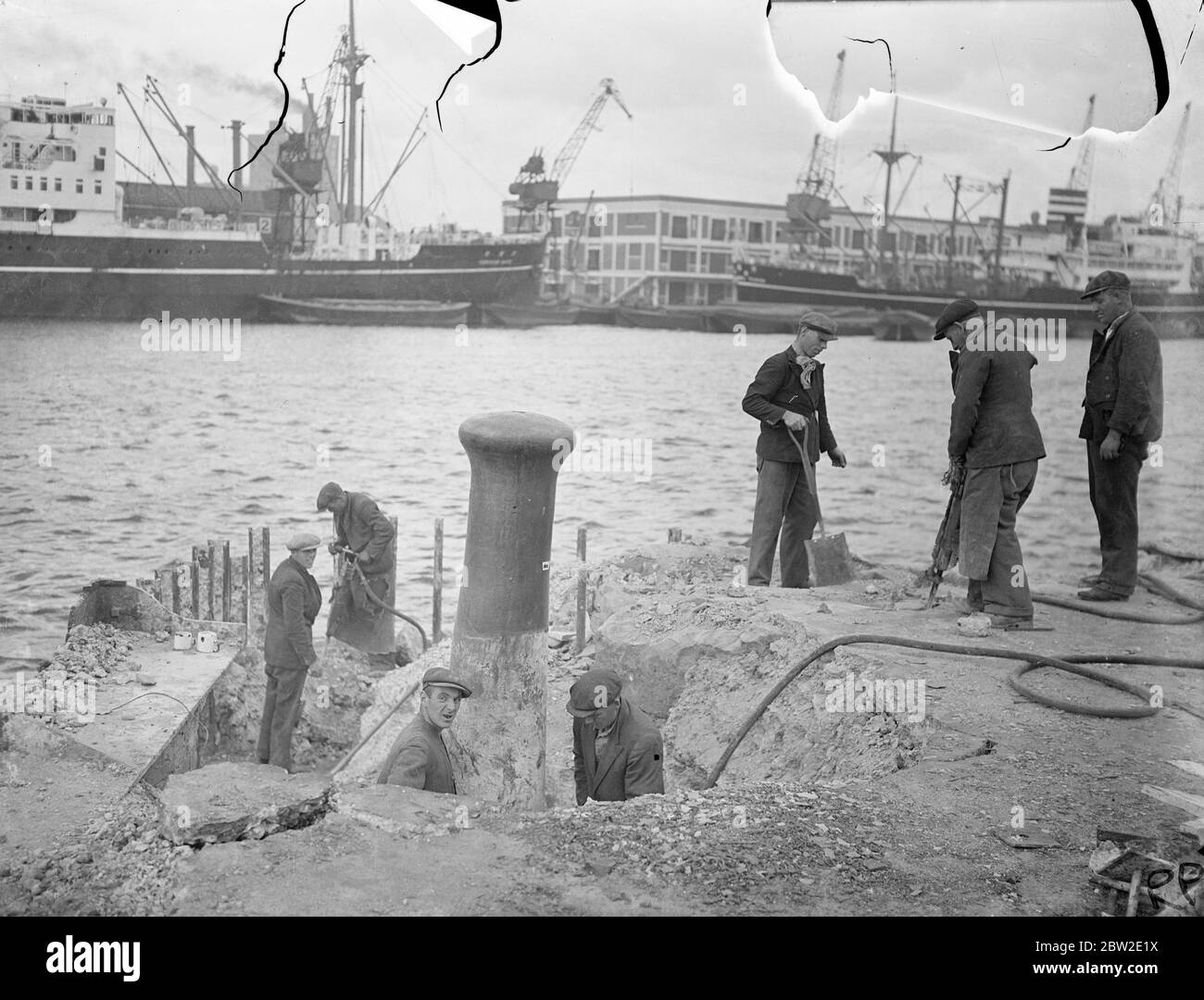 Operai con demolitori in cemento che tagliano parti del vecchio molo G al Royal Victoria Dock, Londra. Sono stati rimossi e costruiti moderni banchine, a causa del tonnellaggio sempre crescente che viene gestito presso i banchine. 23 luglio 1937 Foto Stock